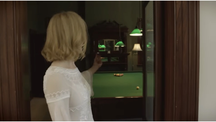 A peek into the billiards room reveals a traditional green-felt pool table beneath pendant lights, with dark wood paneling giving the space a moody, old-world atmosphere. From a video dated July 20, 2015. | Source: YouTube/Vogue