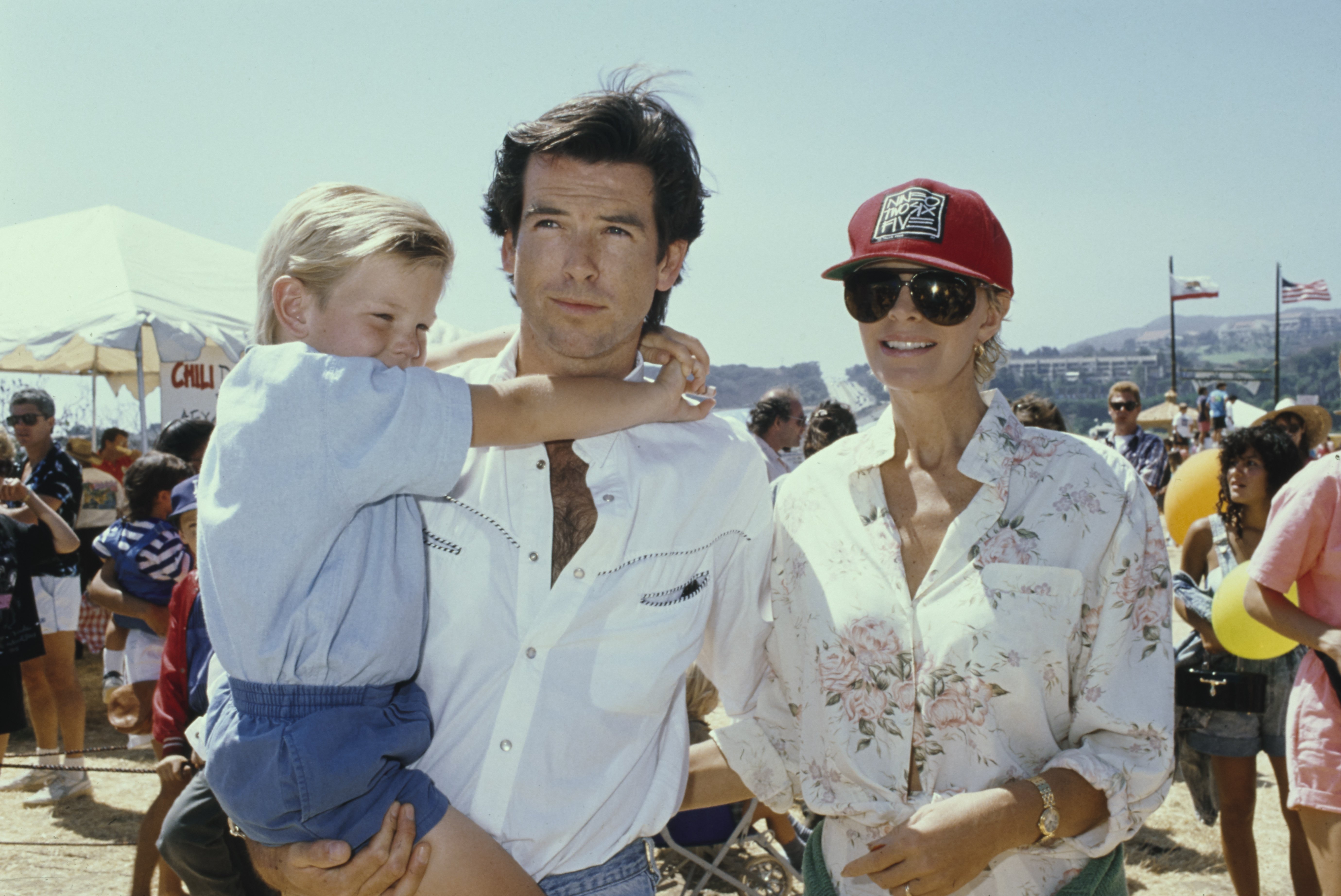 Irish actor Pierce Brosnan with his wife, Australian actress Cassandra Harris and son Sean at the 8th Annual Malibu Kiwanis Chili Cook-off Carnival & Fair, at the Civic Center Area in Malibu, California, 2nd September 1989.