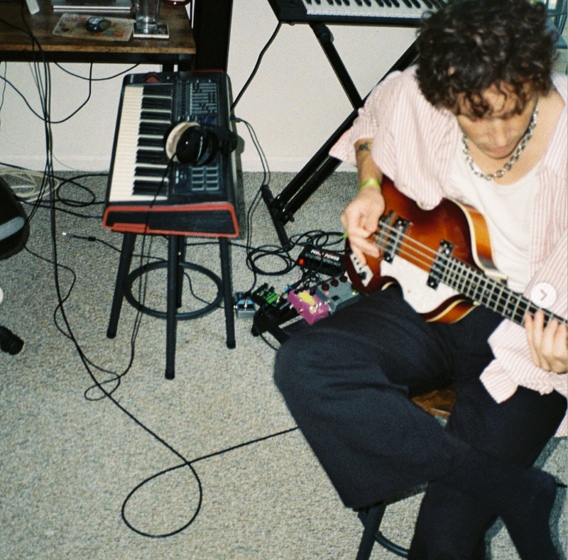 Justin Acee is pictured working on music in a studio, surrounded by instruments and production equipment. The NIGHTIES musician has said he wrote, performed, produced, engineered, mixed and mastered his songs himself, describing the hands-on process. | Source: Instagram/justinacee