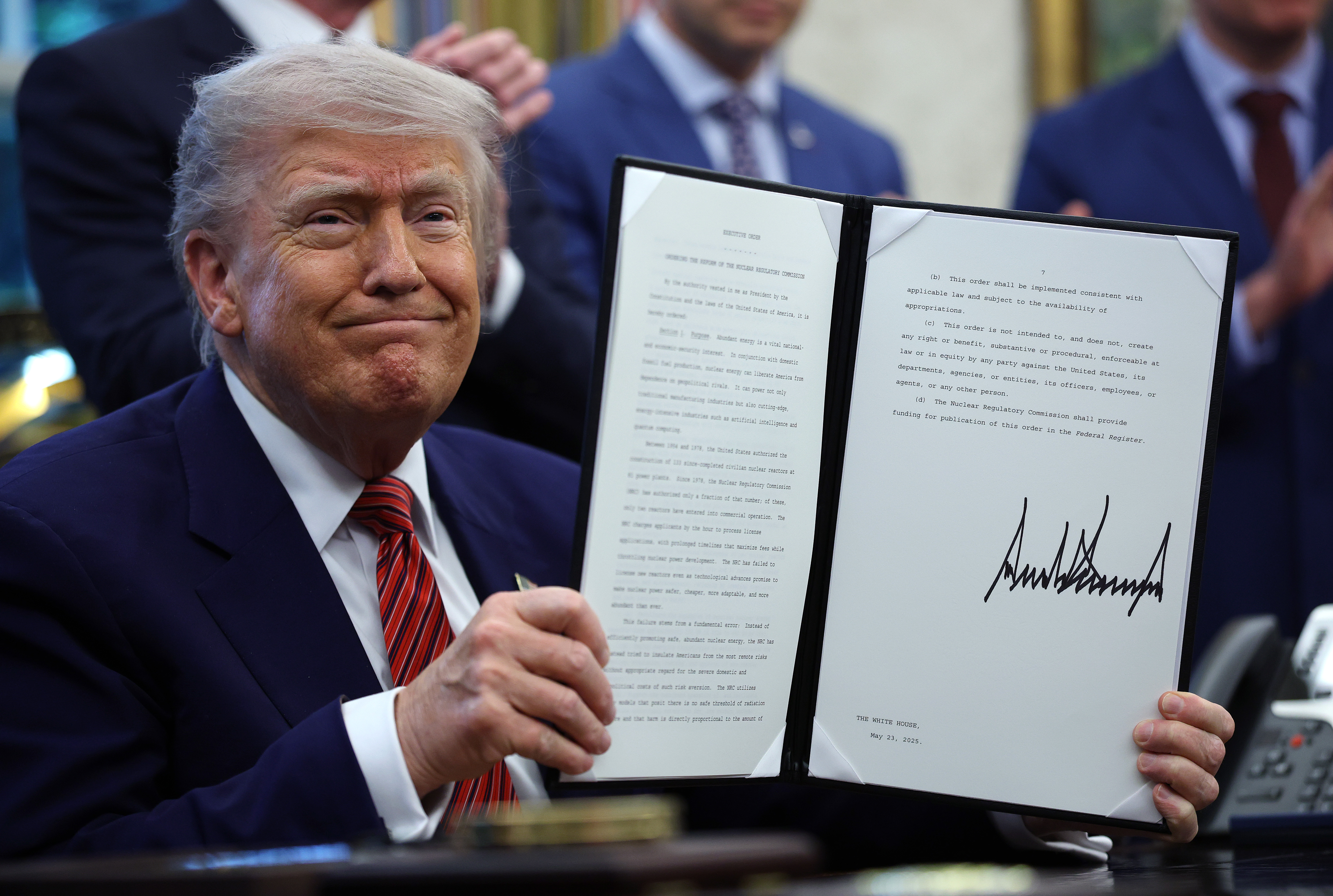 President Donald Trump holds up a signed executive order in the Oval Office of the White House May 23, 2025, in Washington, DC. | Source: Getty Images
