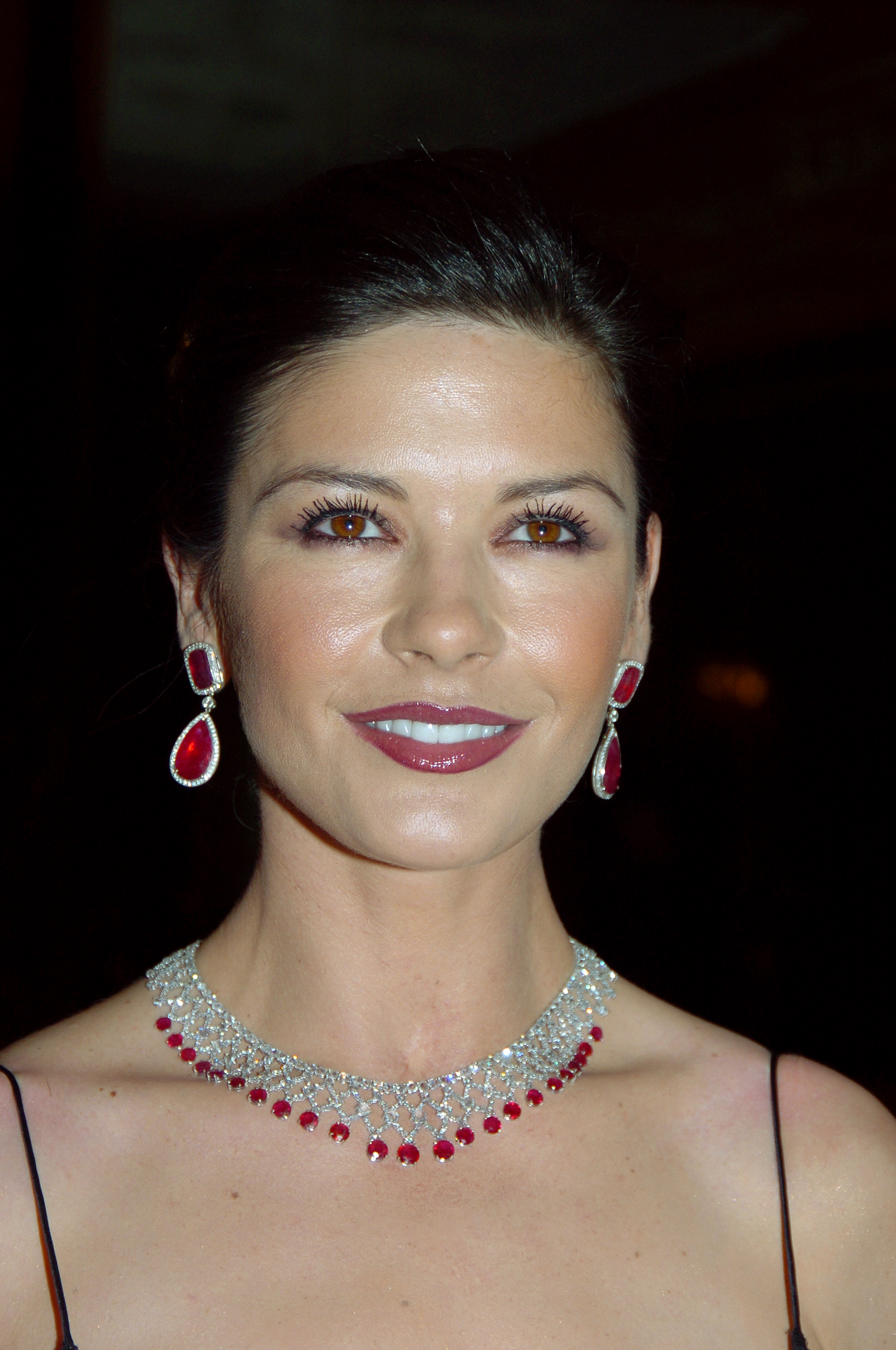 Catherine Zeta-Jones serves as Honorary Chairwoman at the Pierre Hotel for the Eighth Red Ball on February 7 in New York City. She wears a deep berry lip and thin-strapped evening gown, set off by high jewelry including tear-shaped ruby drop earrings and an intricate diamond mesh collar necklace fringed with matching red gemstones.