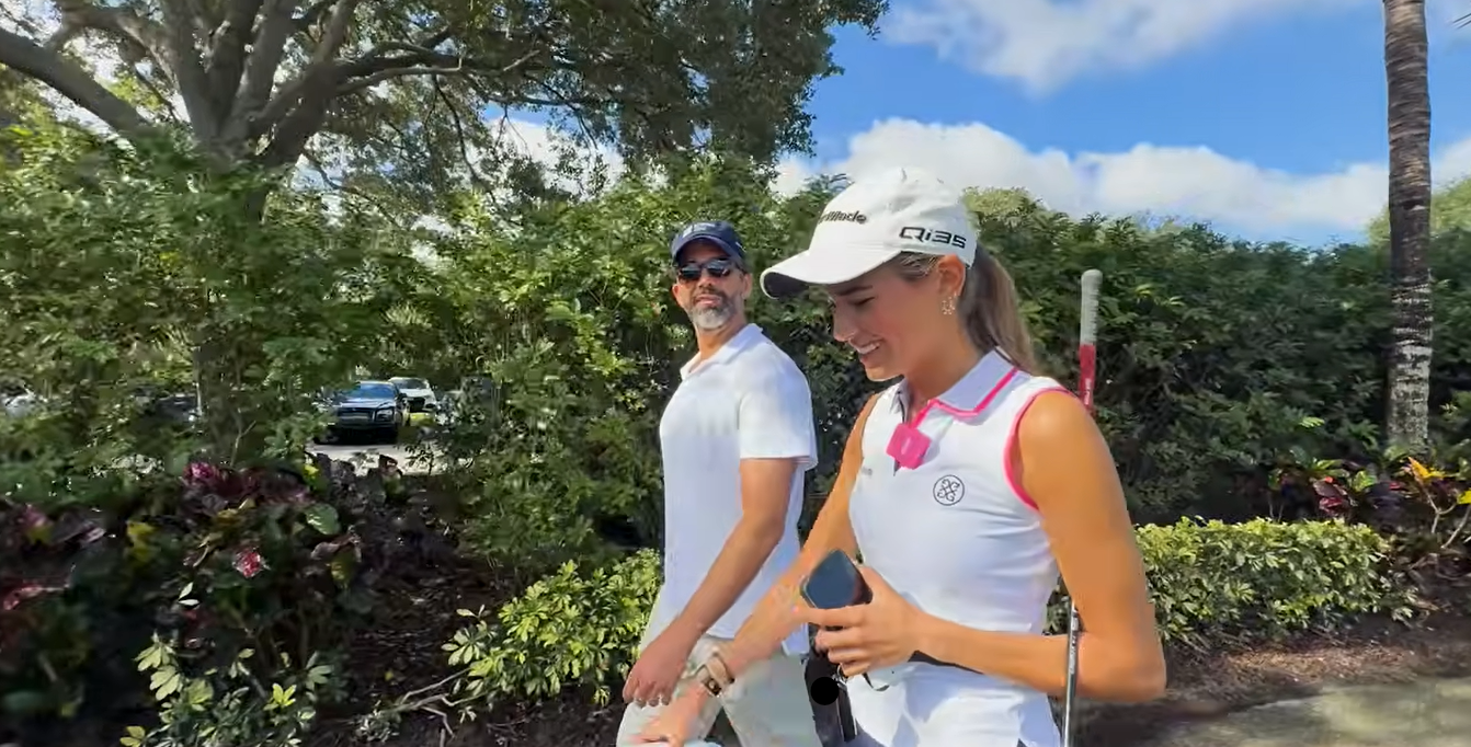 Kai Trump smiles while walking with her father during a visit to a golf course. She told him that she hoped to resume playing full-time in July after missing her original goal of returning by her May birthday. | Source: Youtube/kaitrump