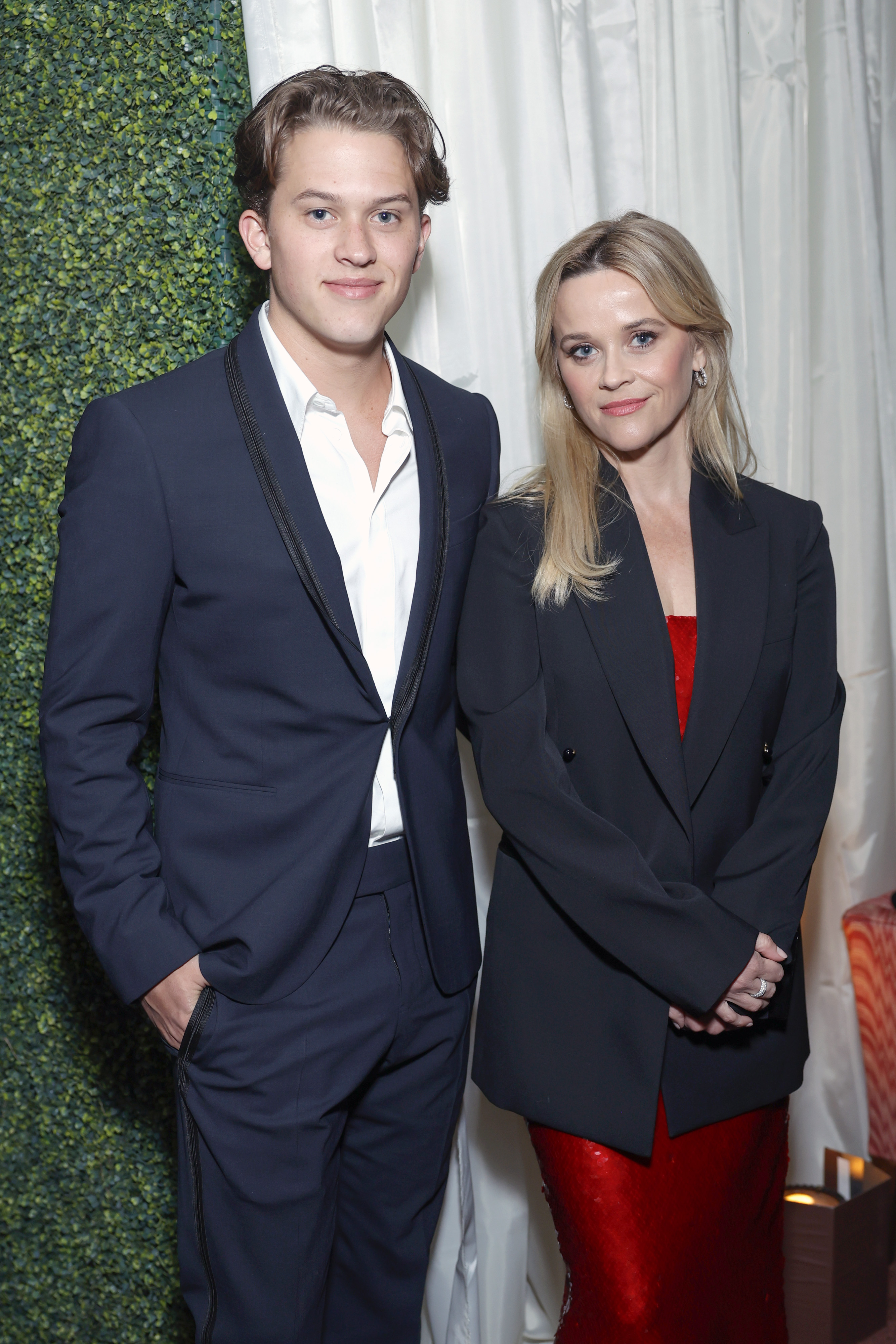 Deacon Reese Phillippe stands beside Reese Witherspoon at a Vanity Fair and Amazon MGM Studios awards season celebration, wearing a navy suit as she opts for a sharp blazer. | Source: Getty Images