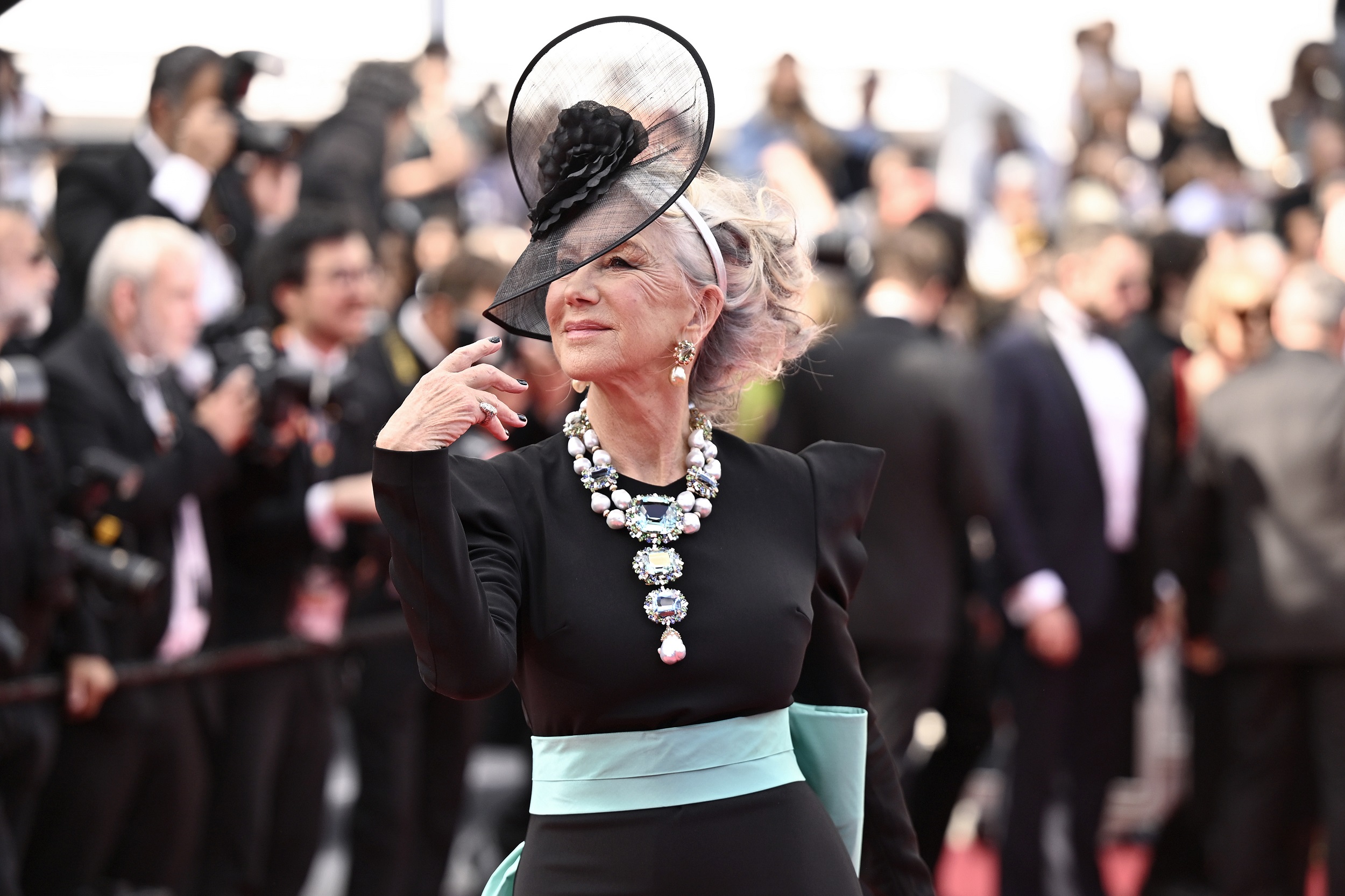 The soft tilt of her head, the graceful lift of her fingers—every motion from Mirren is worthy of a crown. Her necklace, bold and baroque, feels less like an accessory and more like an extension of her majestic flair.