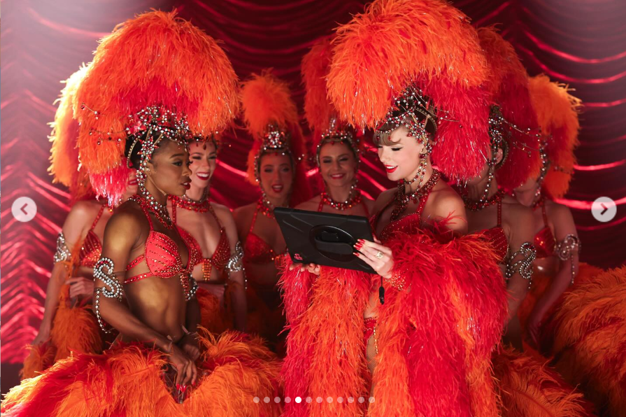 Taylor Swift surrounded by a group of dazzling showgirls from her music video "The Fate of Ophelia," from a post dated October 6, 2025 | Source: Instagram/taylorswift