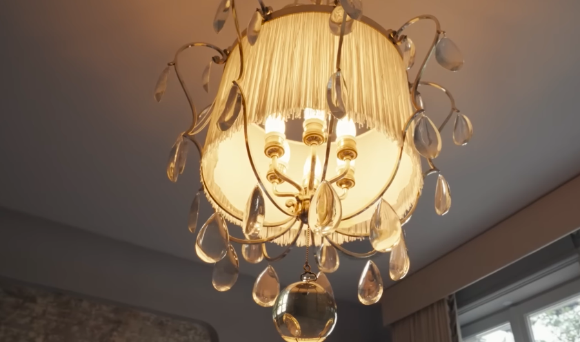 The chandelier feels romantic and slightly theatrical. It is another example of the house's lighting doing major design work. | Source: YouTube/Architectural Digest