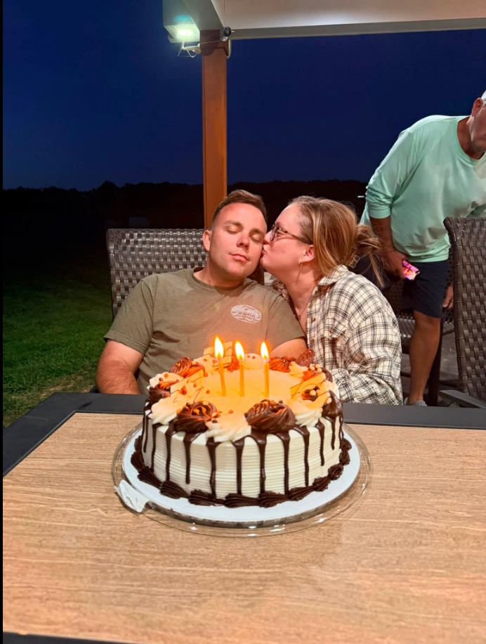 Hayden Phillips and his wife, Jordan, share a tender moment over a birthday cake in a photo she shared in her tribute. Jordan remembered the memories they made together and the love she had for the husband and father of her three sons. | Source: Facebook/Jordan Phillips