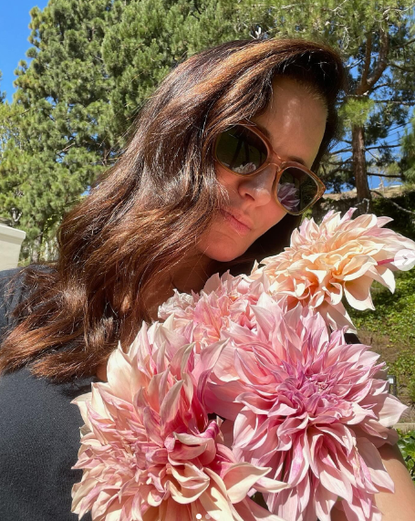 Kristin Davis poses while holding flowers, dated March 20, 2024. | Source: Instagram/iamkristindavis