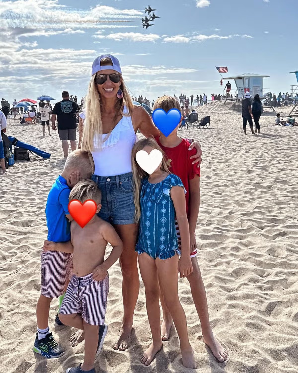 Katie has always tried to protect her four children from the public spotlight, even covering their faces with heart emojis in this rare family photo from a beachside air show. | Source: Instagram/@katiezacharia