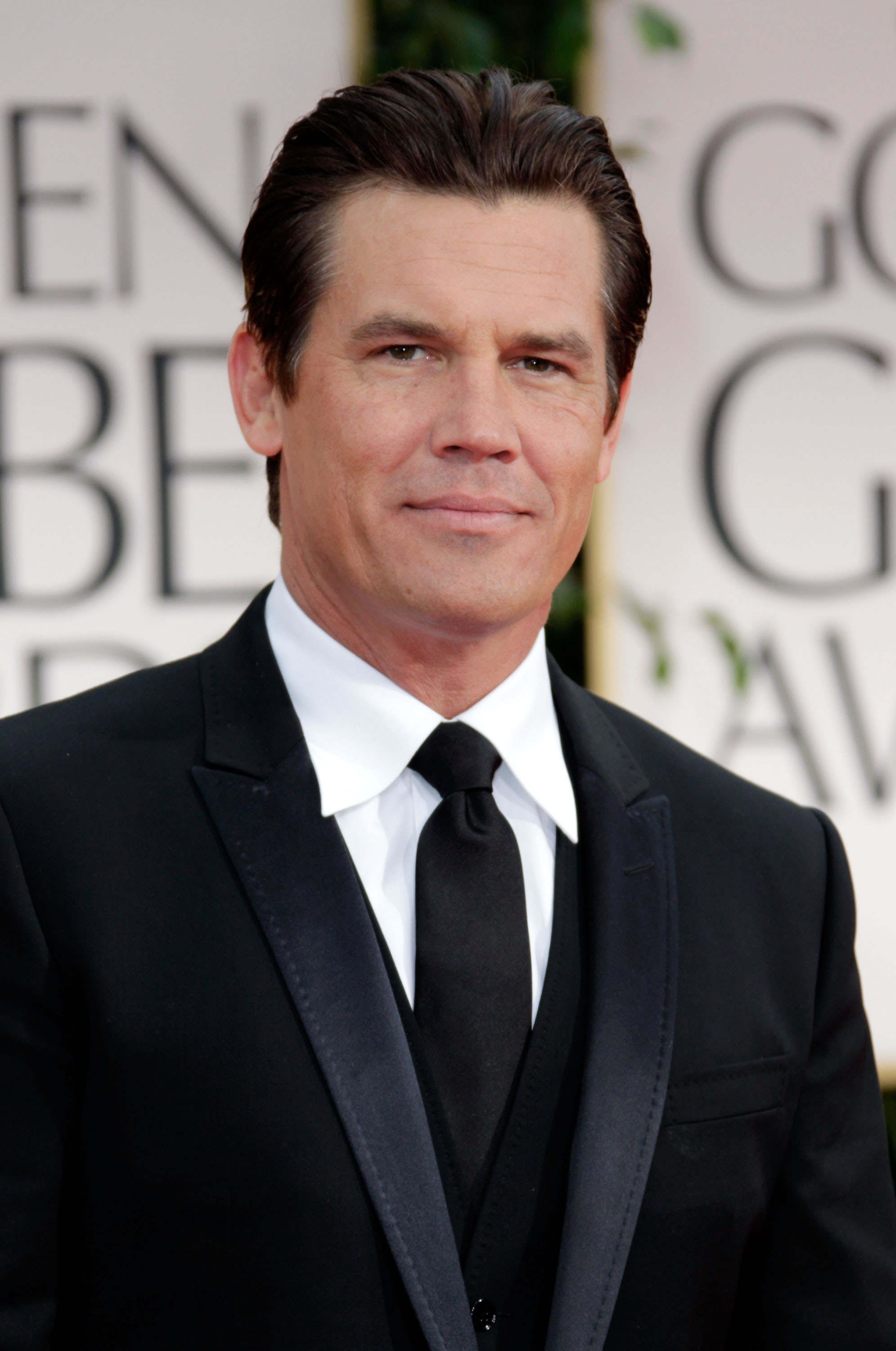 Wearing a black tuxedo with satin lapels and a crisp white shirt, he appears clean-shaven with neatly combed hair — a polished, formal look that contrasts sharply with the rugged style he would adopt in later years.
