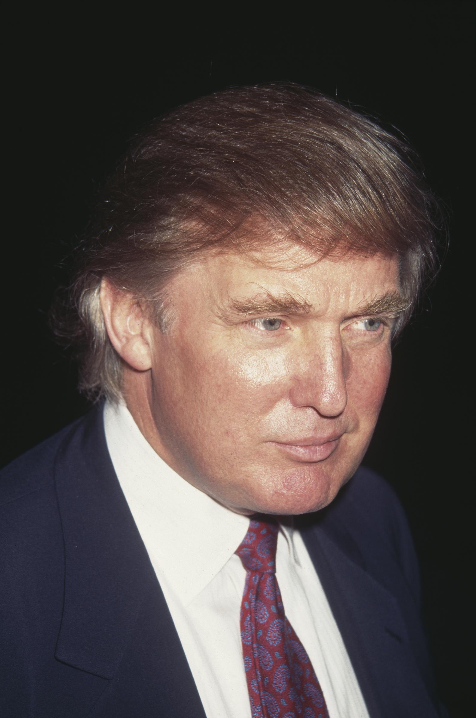 Donald Trump's hair appears lighter and more reddish-brown than in earlier years as he attends a Friars Club roast in New York City on October 6, 1995.