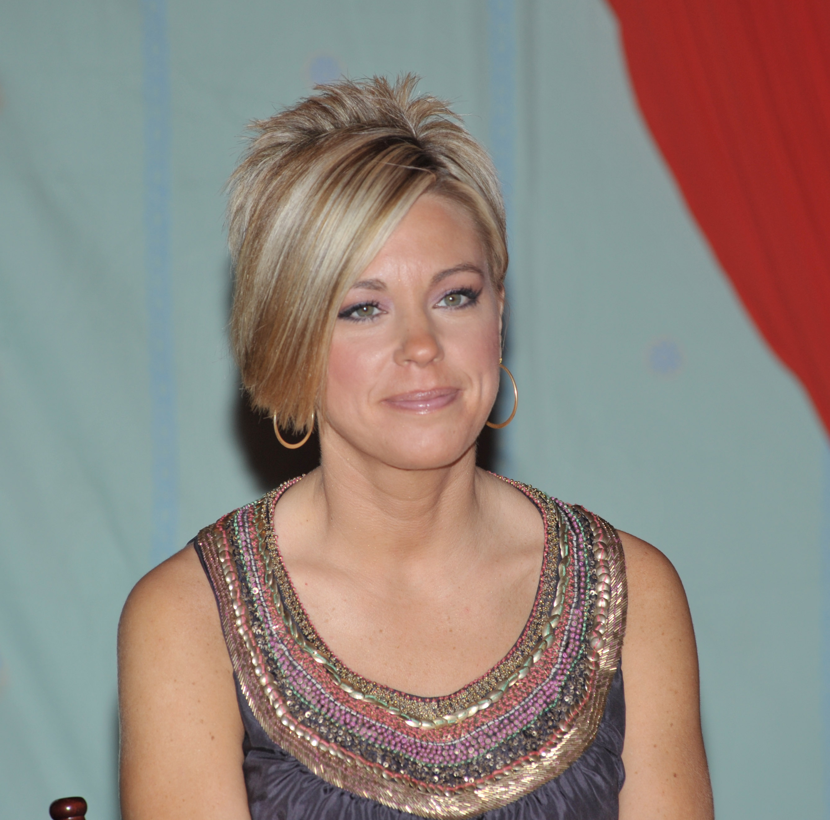 At the Women's Conference in Long Beach, Kate Gosselin wears a sleeveless embellished top with shimmering detail. Her short blonde cut and hoop earrings give her a bold, polished look that reflects her early reality TV style.