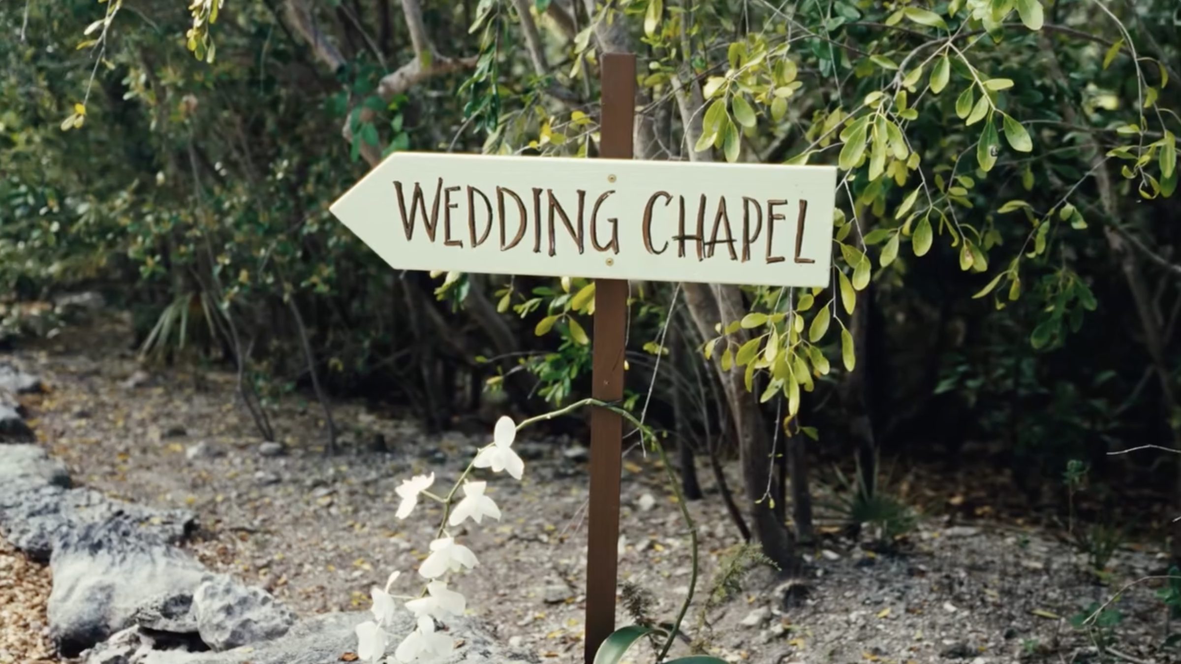 A rustic sign points guests toward the wedding chapel nestled among tropical greenery on the Bahamas property. | Source: Instagram/donaldjtrumpjr