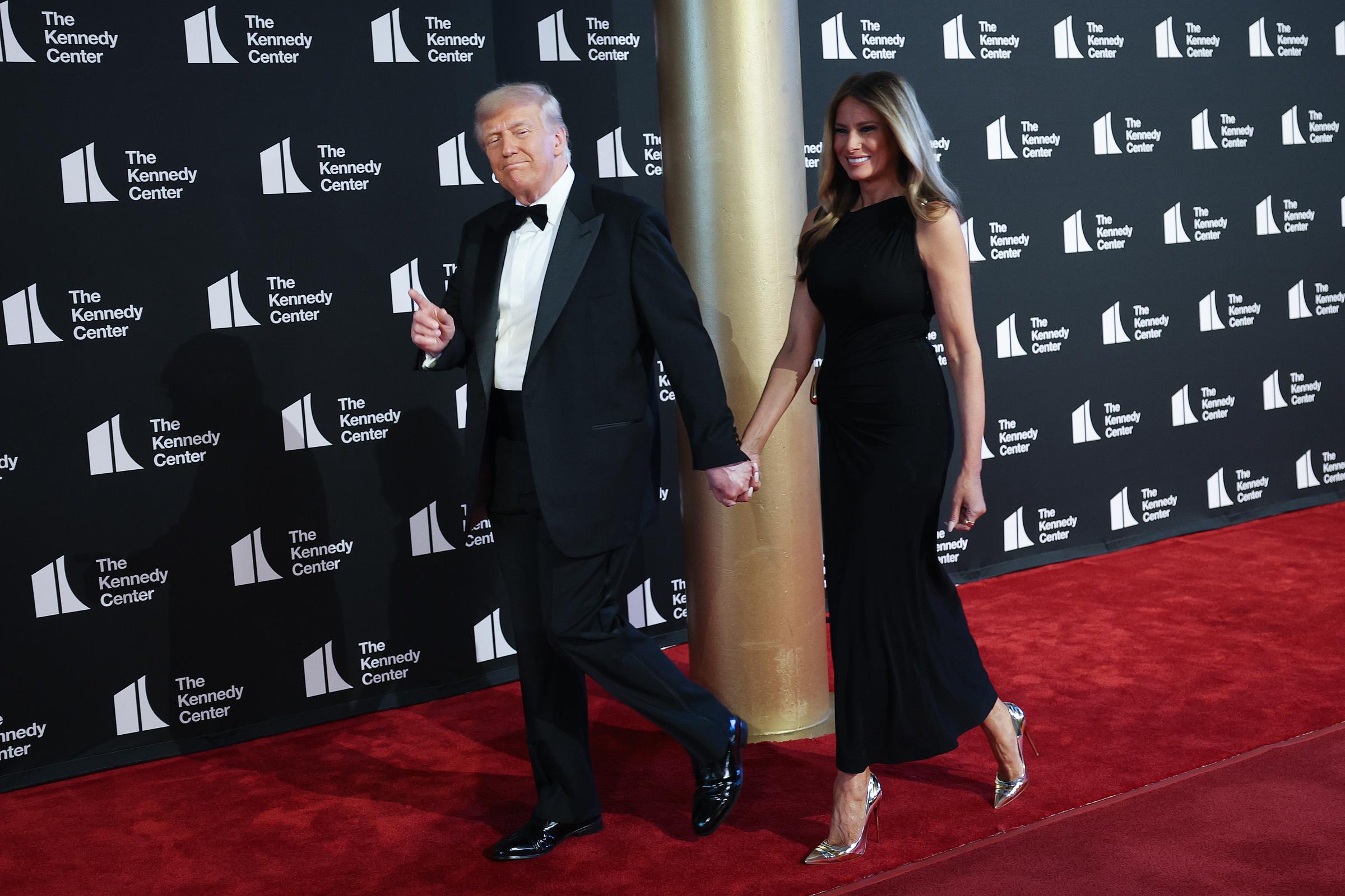 With a thumbs-up and a slight grin, the president leads the first lady down the red carpet as they arrive for Les Misérables, drawing cameras and attention at the Kennedy Center.