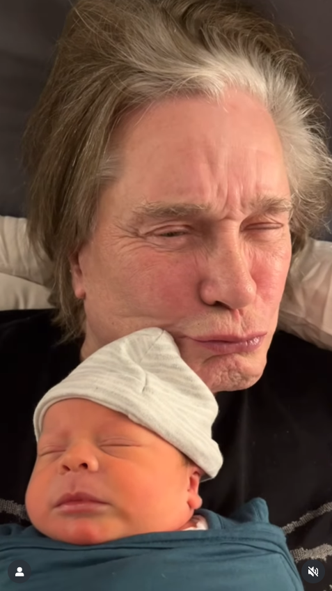 Ozzy Osbourne photographs with his grandchild, from a video post dated June 15, 2025 | Source: Instagram/kellyosbourne