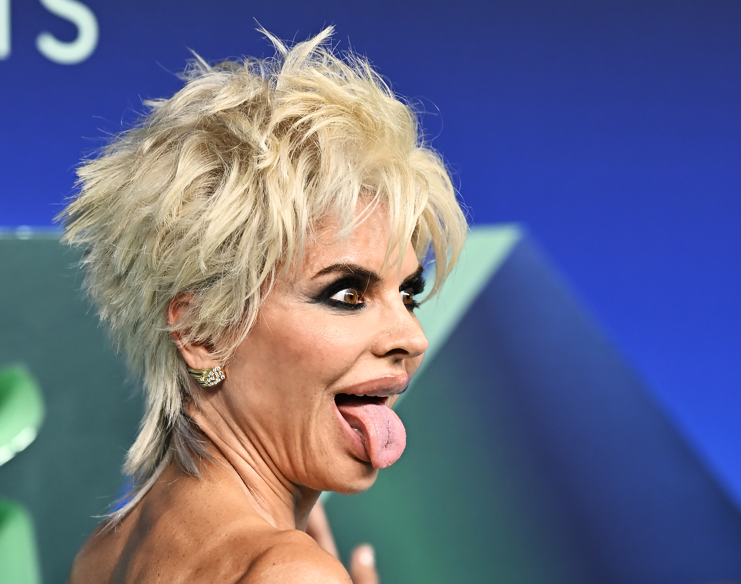 Rinna flashes a playful pose for photographers as she sticks her tongue out and widens her eyes. Her Madonna-inspired look, from her hair to her dress, caused quite the commotion online, with many viewers finding issues with the dress' construction, specifically. | Source: Getty Images