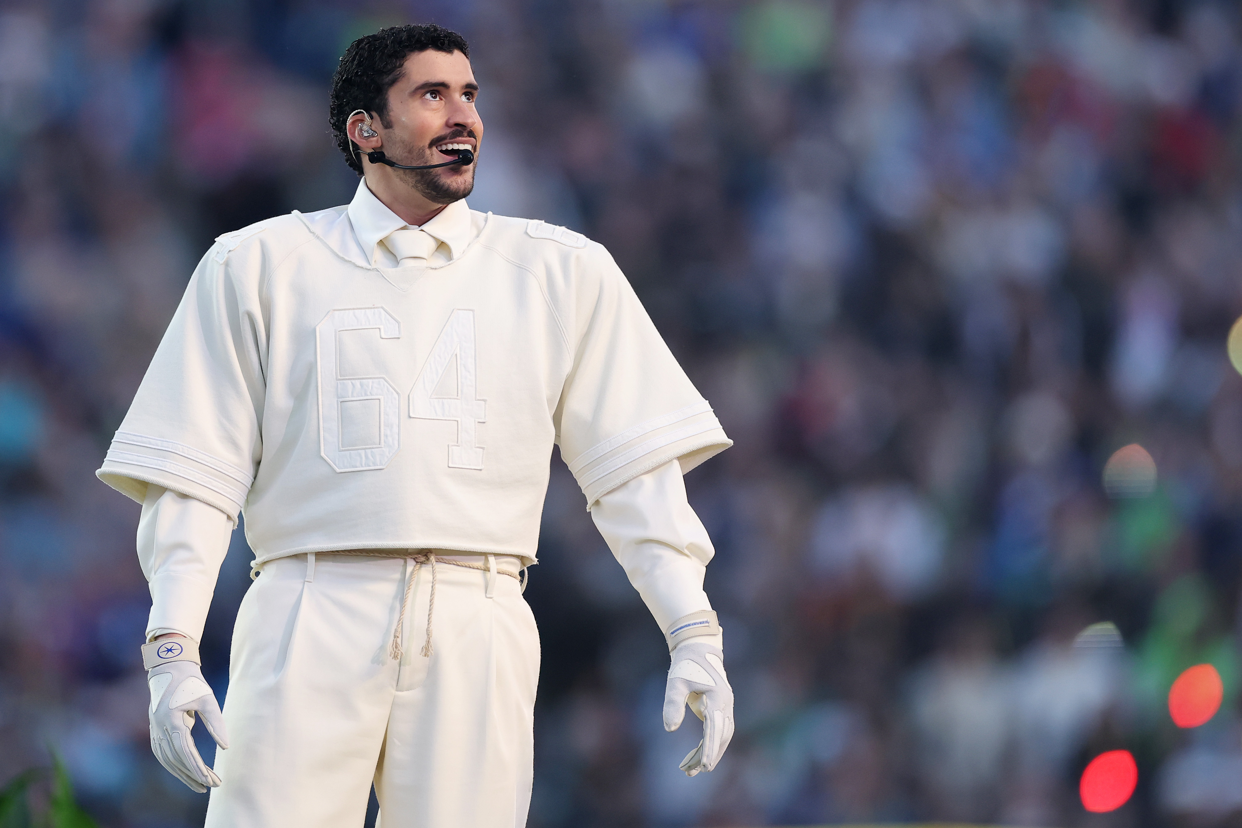 Bad Bunny performs during the Super Bowl 2026 Halftime Show, wearing an all-white outfit as he takes the stage in front of a packed stadium audience, in Santa Clara, California on February 8, 2026. | Source: Getty Images