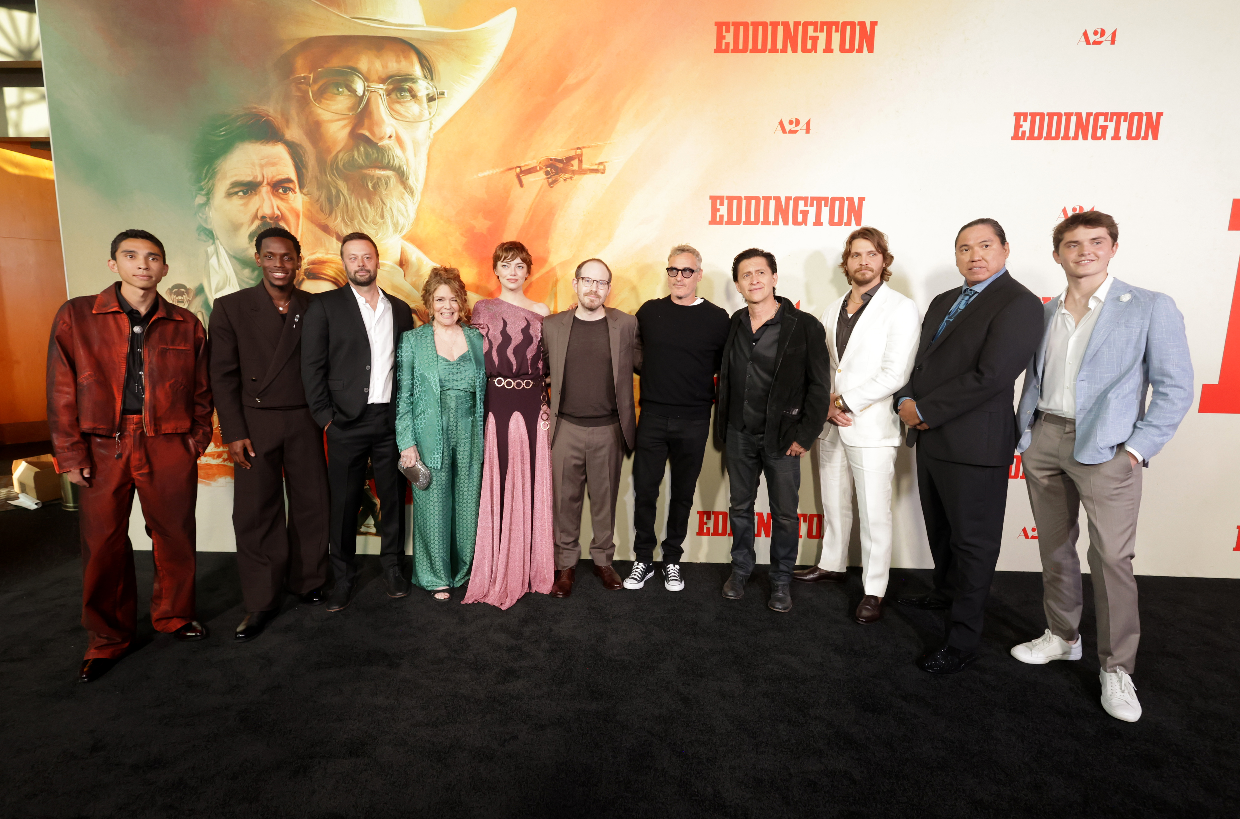 Stone stands alongside Matt Gomez Hidaka, Micheal Ward, producer Lars Knudsen, Deirdre O'Connell, writer/director/producer Ari Aster, Joaquin Phoenix, Clifton Collins Jr., Luke Grimes, William Belleau, and Cameron Mann at the "Eddington" premiere.