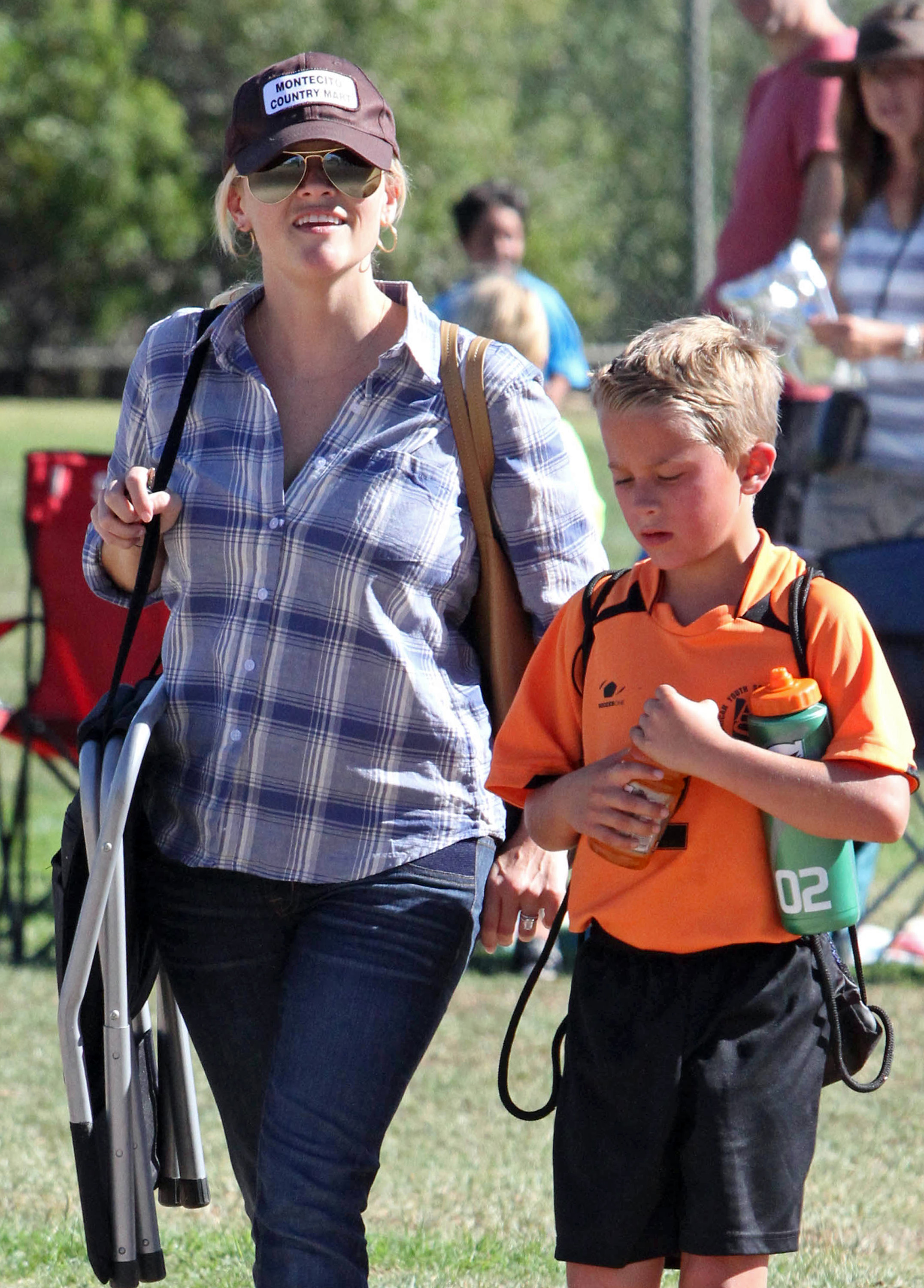 A young Deacon stayed close to Reese during a casual outing in Los Angeles, sporting an orange jersey and carrying his water bottle. The everyday moment showed a more relaxed side of life away from Hollywood events.