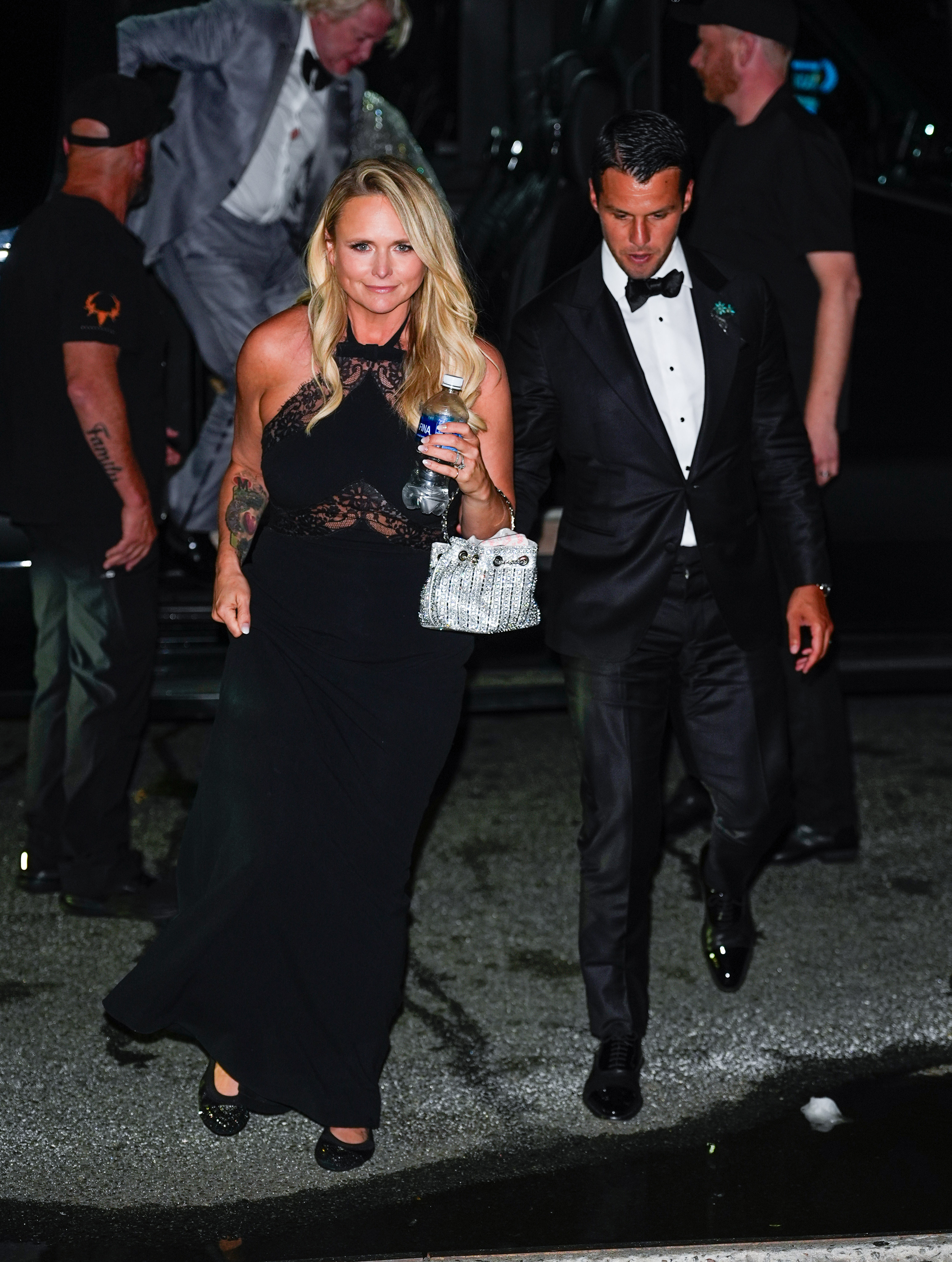 Miranda Lambert and Brendan McLoughlin stepped out in glamorous evening wear as they returned from the wedding of Taylor Swift and Travis Kelce on July 3, 2026, in New York City. Miranda looked radiant in a black halter-neck gown featuring delicate lace detailing across the bodice, accessorizing with a glittering silver purse and dark flats. Walking closely alongside her, Brendan looked dapper in a classic black tuxedo, bow tie, and patent leather shoes. | Source: Getty Images