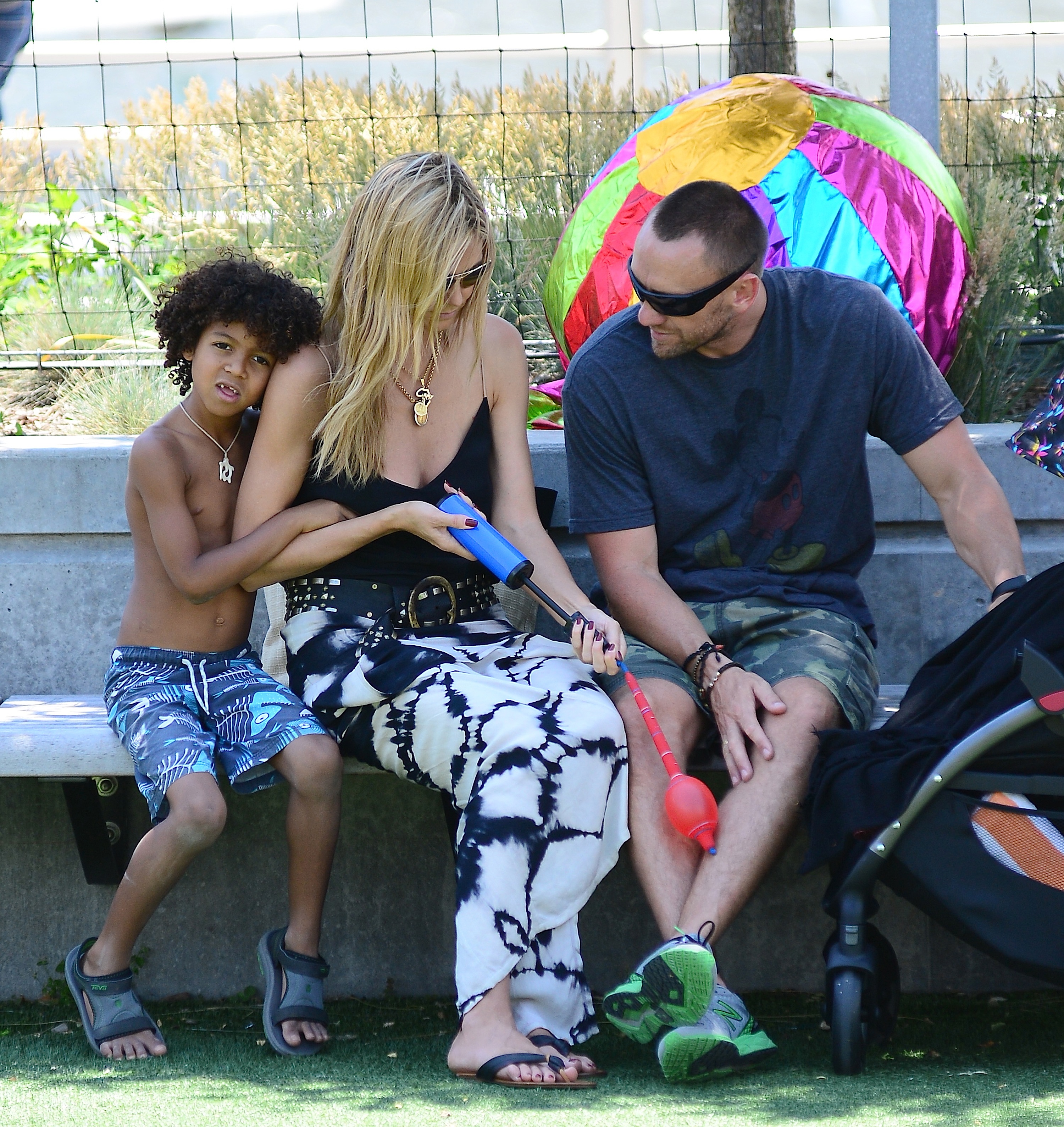 Johan Samuel sits beside Heidi Klum as she talks with Martin Kristen at Tribeca Hudson River Park in New York City on June 20, 2013 | Source: Getty Images