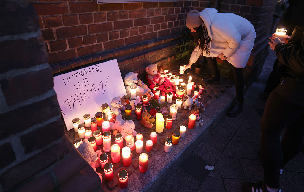 October 14, 2025, Mecklenburg-Vorpommern, Güstrow: Before the start of a funeral service, participants place candles and mementos in front of St. Mary's Church after the body of a child was found in a forest near Güstrow. | Source: Getty Images