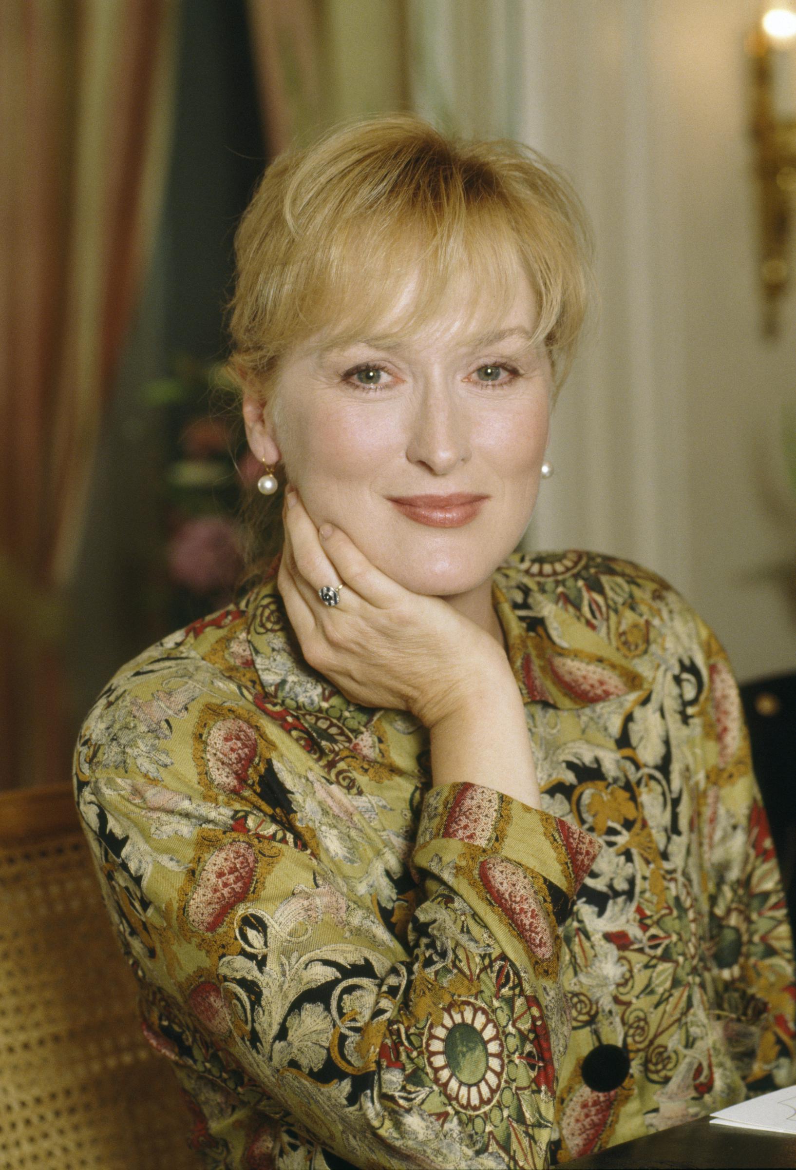 Meryl Streep is shown in a portrait taken in 1992, wearing a patterned blouse and resting her hand against her face | Source: Getty Images