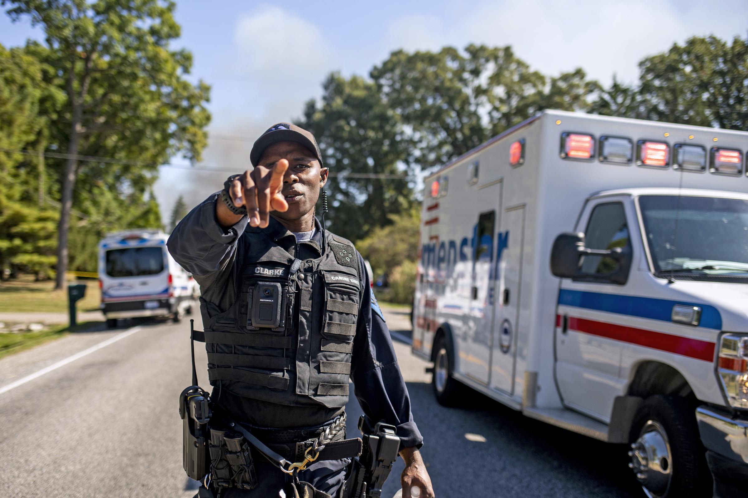An officer motions to vehicles on a street where emergency services respond to a shooting and fire at the Church of Jesus Christ of Latter-day Saints on September 28, 2025, in Grand Blanc, Michigan. | Source: Getty Images