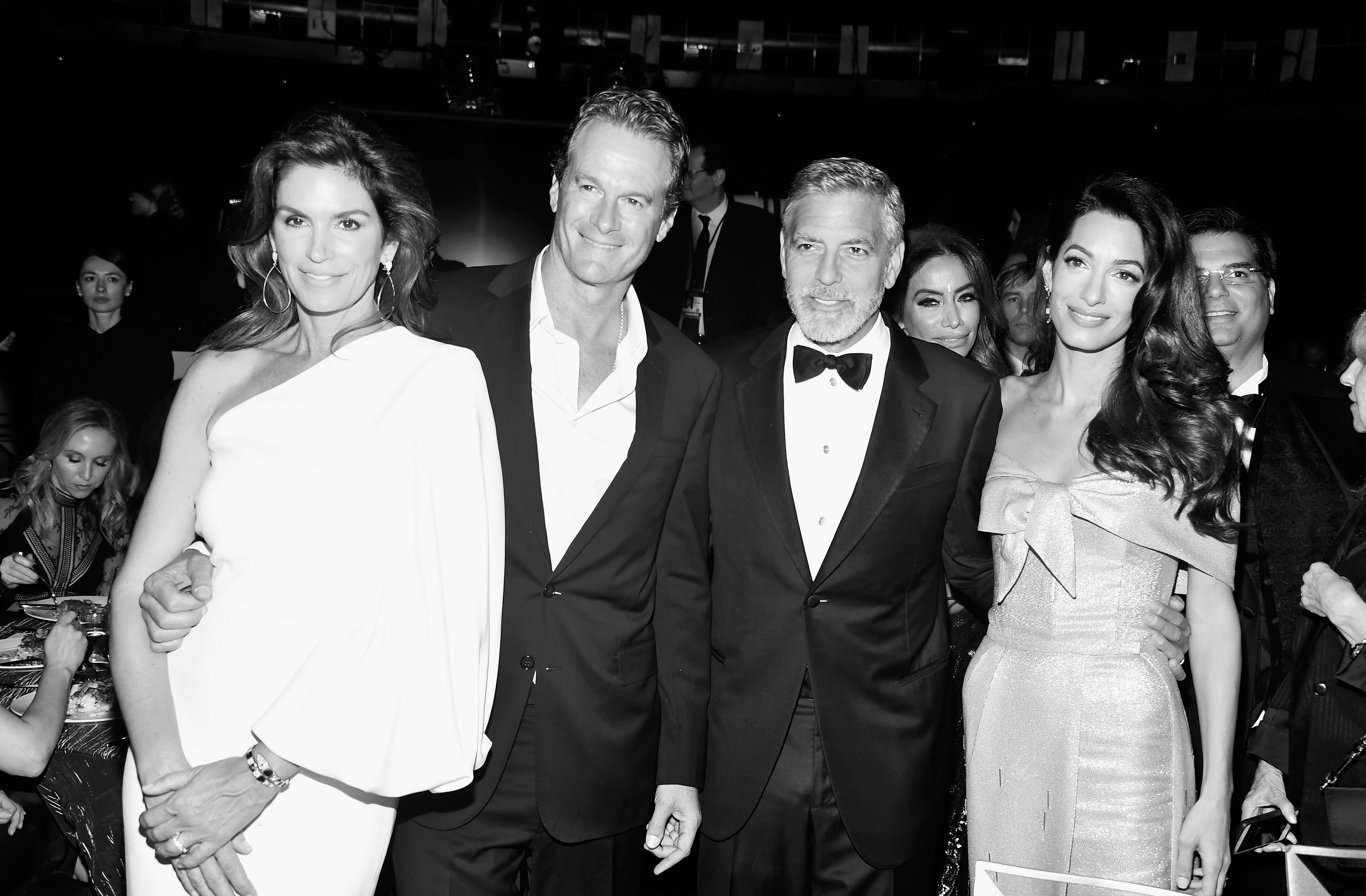 Cindy Crawford, Rande Gerber, George Clooney, and Amal Clooney made a glamorous foursome at the American Film Institute's 46th Life Achievement Award Gala Tribute honoring George on June 7, 2018, at the Dolby Theatre in Hollywood, California. Posing closely in a timeless black-and-white portrait, Cindy turned heads in a one-shoulder white gown beside Rande in a sharp suit and open collar, while George looked dashing in a classic tuxedo and bow tie with his arm around Amal, who stunned in an off-the-shoulder bow dress. | Source: Getty Images