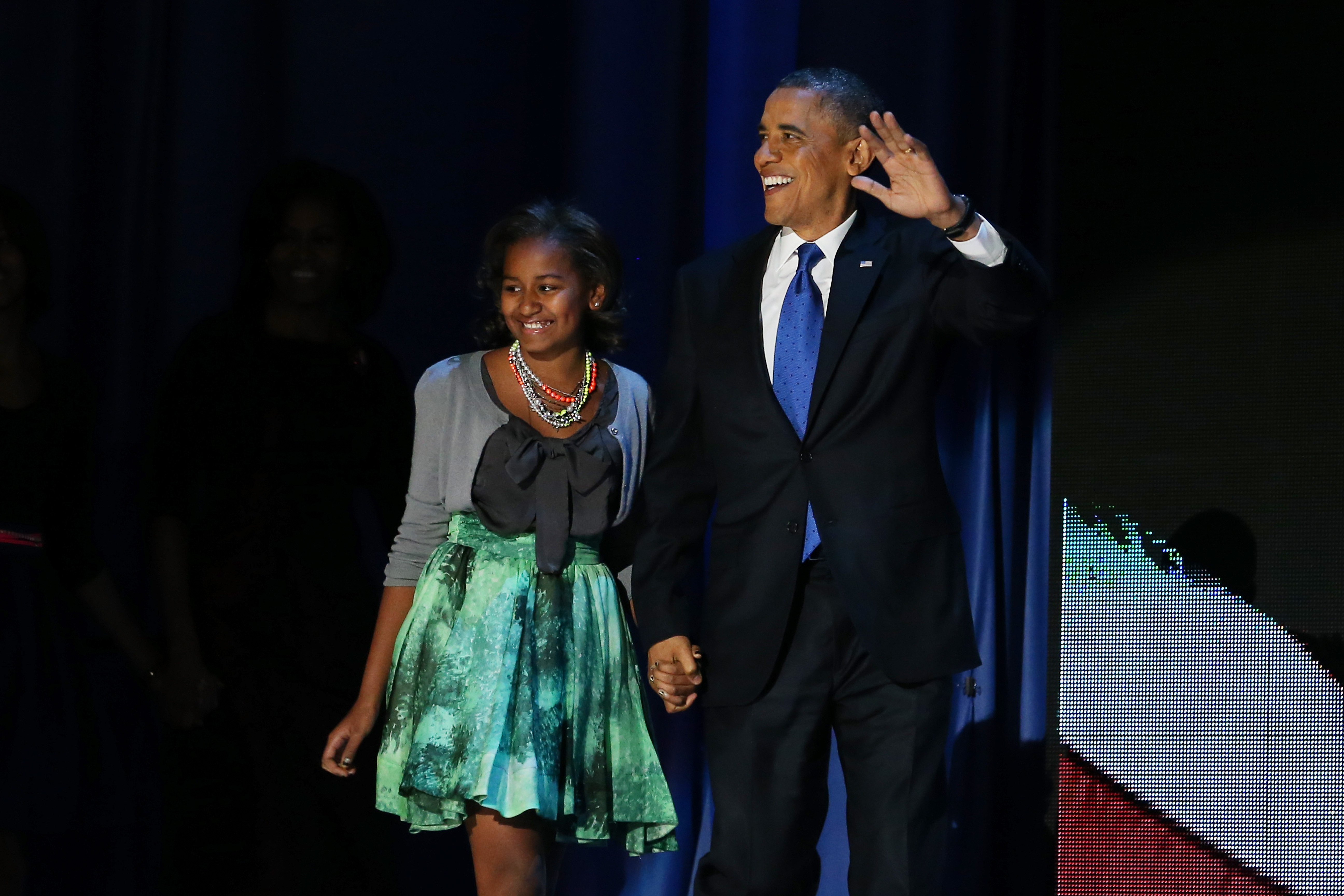 On election night, November 6, 2012, in Chicago, Illinois, Sasha Obama — dressed in a gray cardigan, green skirt, and layered necklaces — joined her father, Barack Obama, onstage to greet supporters during his second-term victory speech.