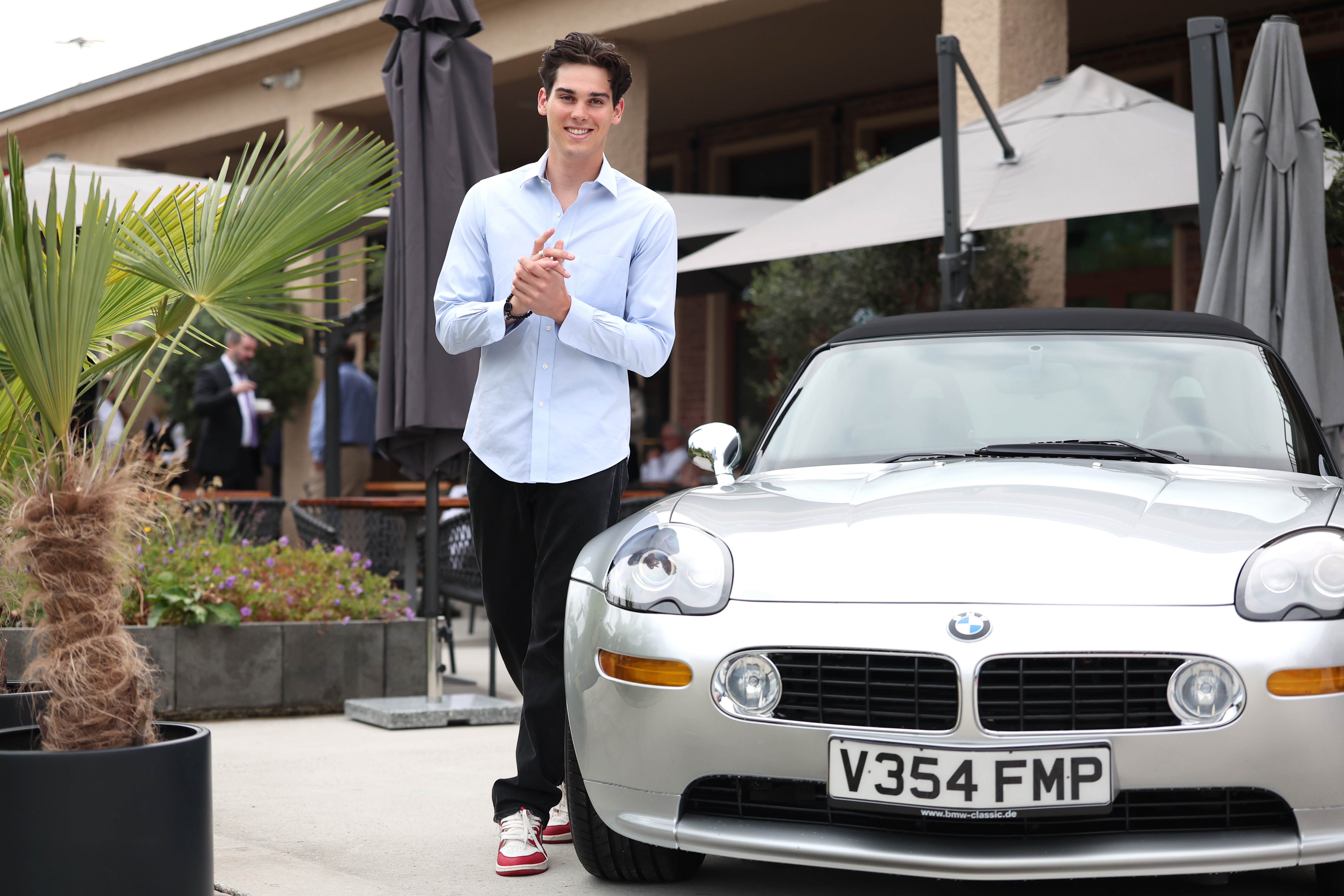 Paris Brosnan with the BMW Z8, which his father Pierce Brosnan drove during the James Bond 007 "The World Is Not Enough" film from 1999, on July 15, 2025 in Munich, Germany | Source: Getty Images