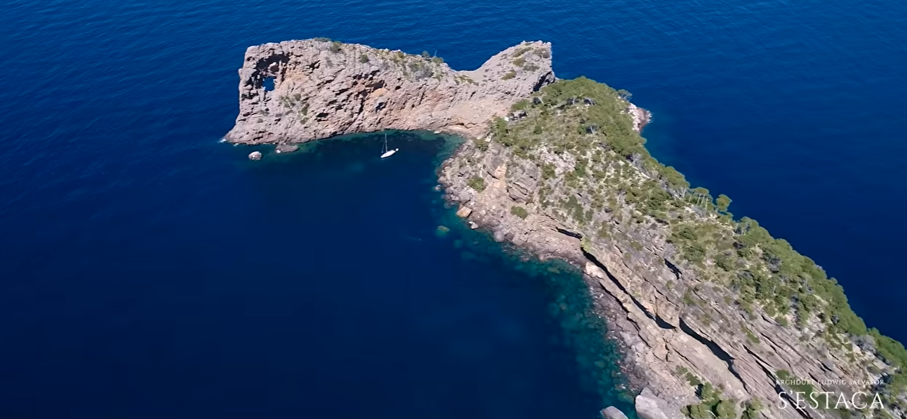 Deep blue water surrounds a rocky formation off Mallorca's coast. The striking landscape helps show why S'Estaca's location is such a major part of the property's appeal. | Source: YouTube/billionsluxuryportal