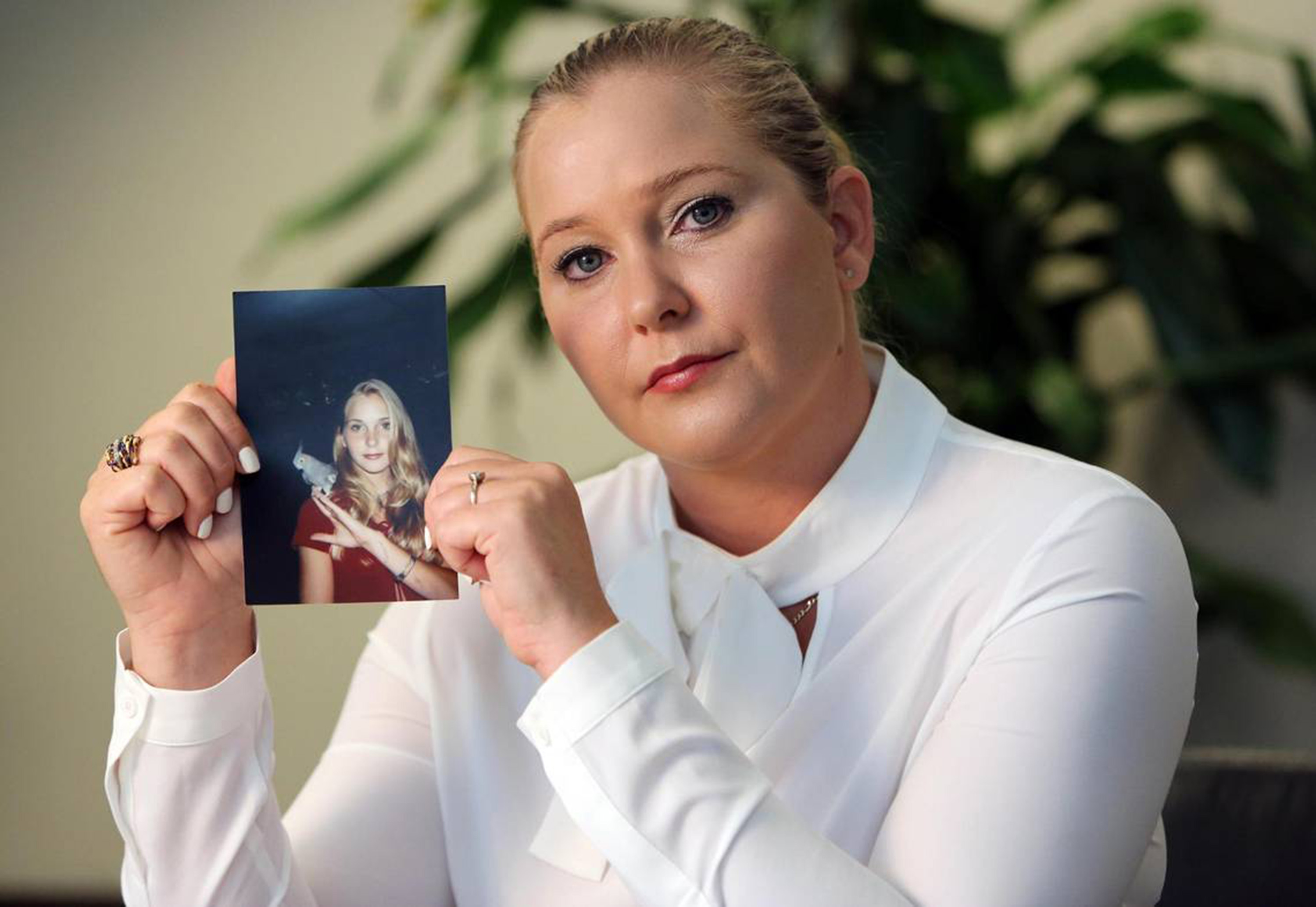 Virginia Giuffre, with a photo of herself as a teen, when she says she was abused by Jeffrey Epstein, Ghislaine Maxwell, and Prince Andrew, among others, dated March 1, 2023 | Source: Getty Images