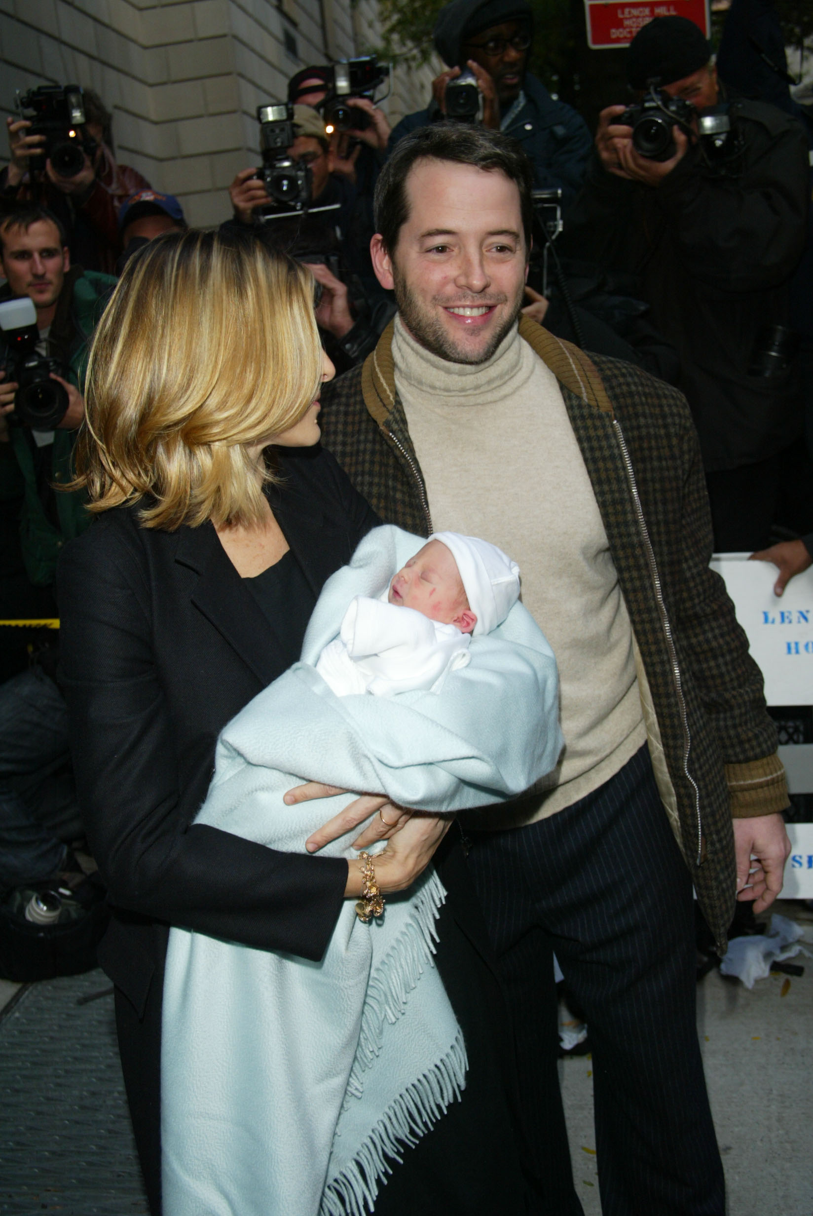Sarah Jessica Parker and Matthew Broderick leave New York City's Lennox Hill Hospital carrying their newborn son, James Wilkie Broderick, wrapped in a light blue blanket just days after his birth. Photographers gathered outside as the couple made their first public appearance with their baby boy.