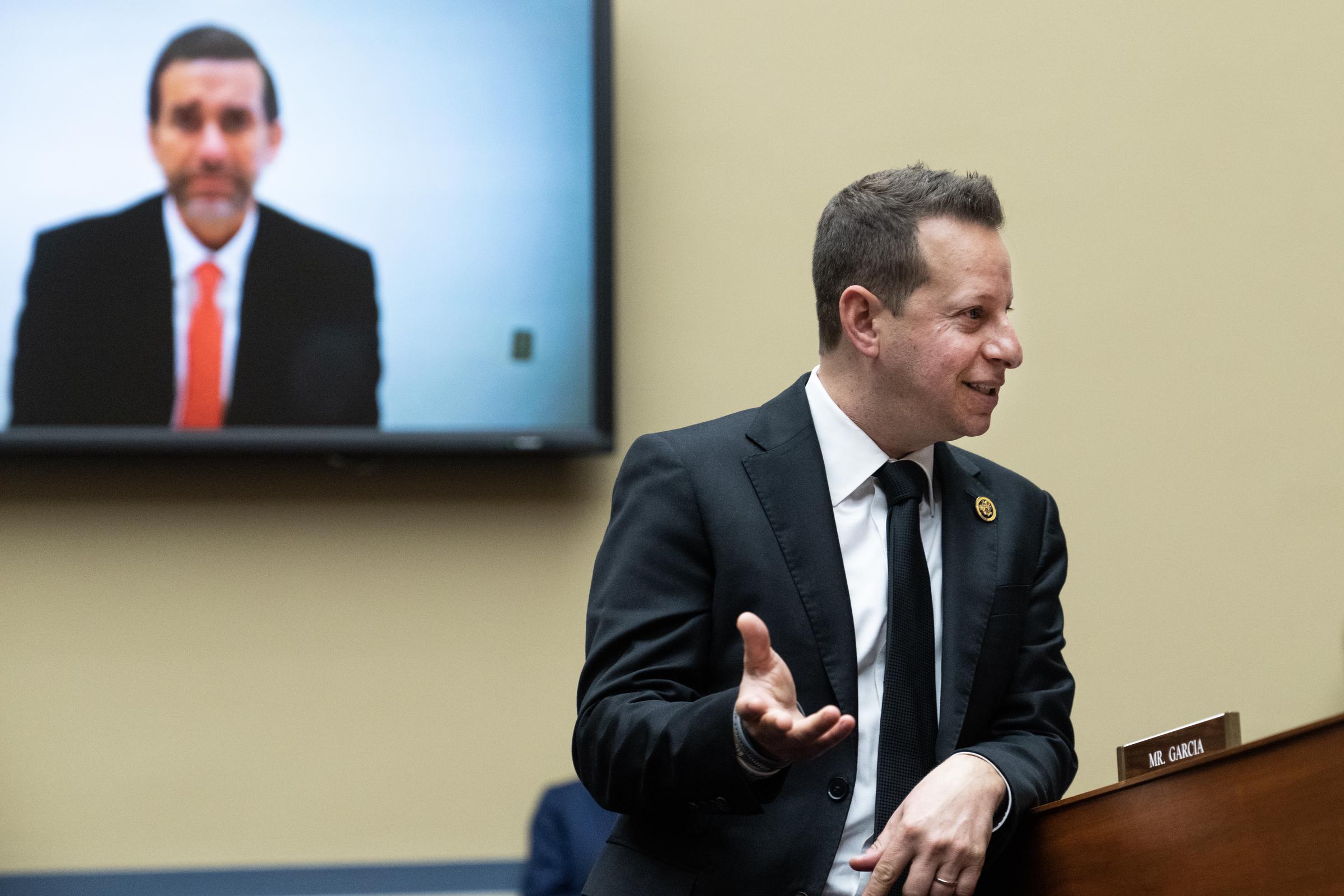 Jason Galanis appears on a screen during a congressional hearing in March 2024. His past has attracted fresh attention following his engagement to Savannah Chrisley. | Source: Getty Images