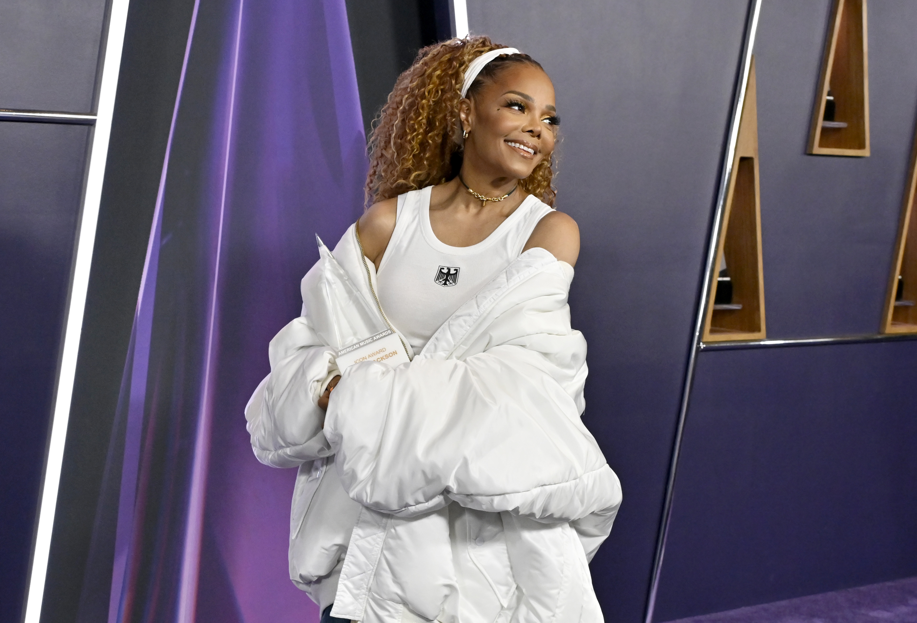 With a radiant smile and relaxed posture, she lets her natural charm shine through the oversized silhouette of her jacket and carefree locks.