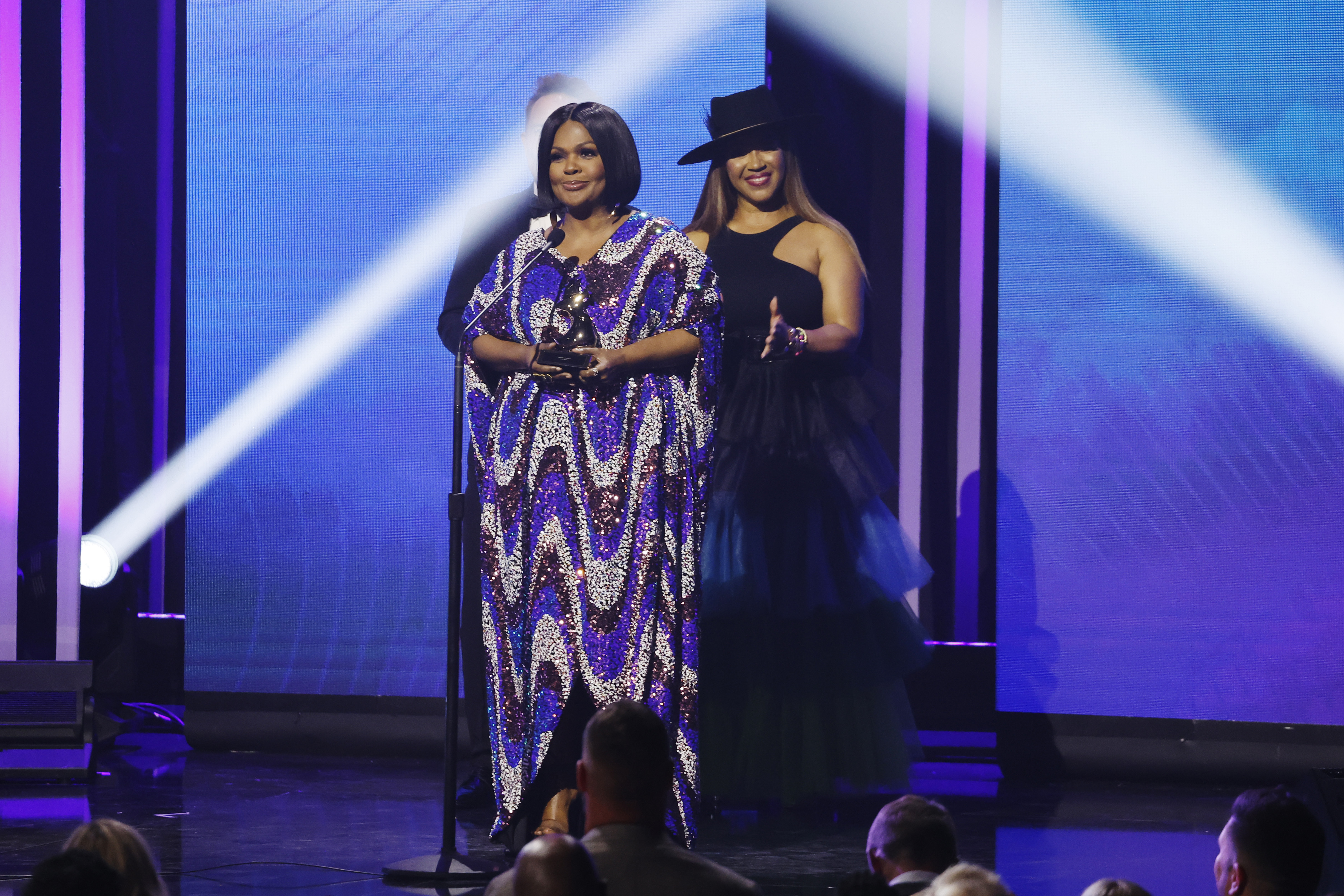 CeCe Winans gestures while speaking beside host Erica Campbell onstage during the 53rd Annual GMA Dove Awards in Nashville, Tennessee, on October 18, 2022.