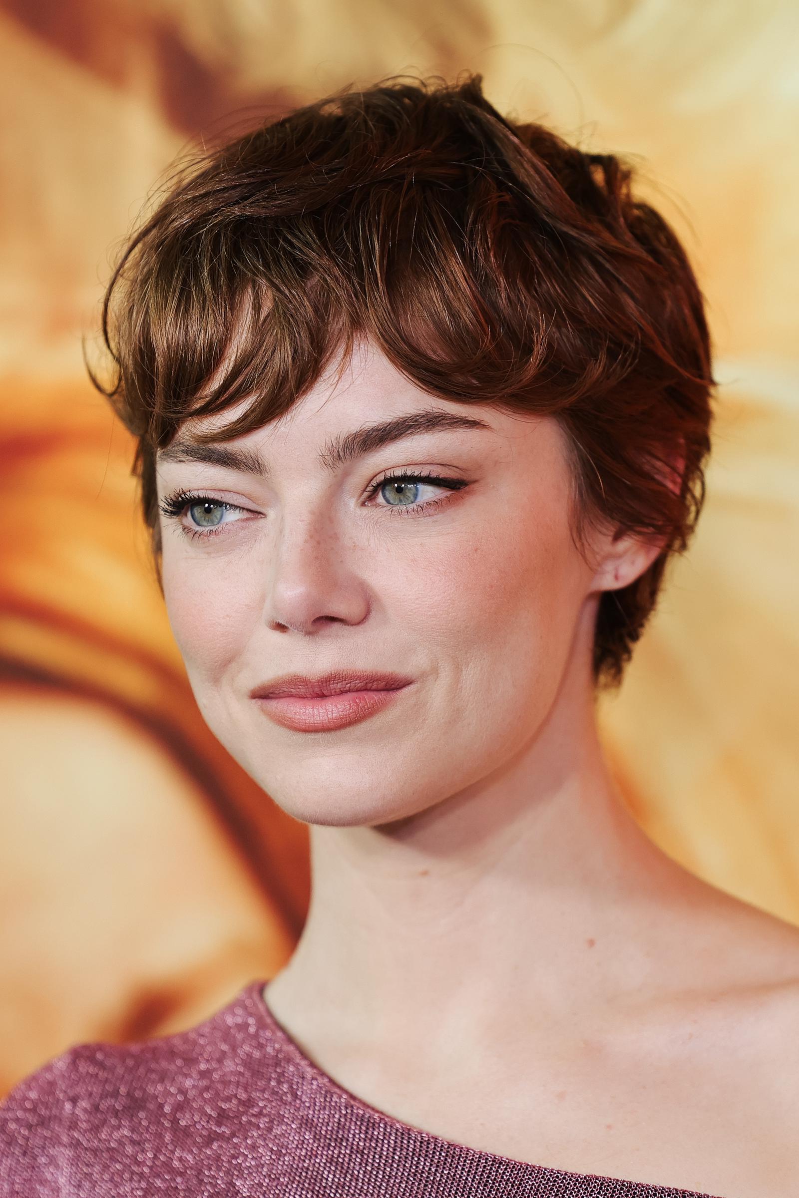 Stone sported a sleek pixie cut, styled by Mara Roszak, with a rich auburn hue and soft, natural waves. This textured style beautifully enhanced her striking features.