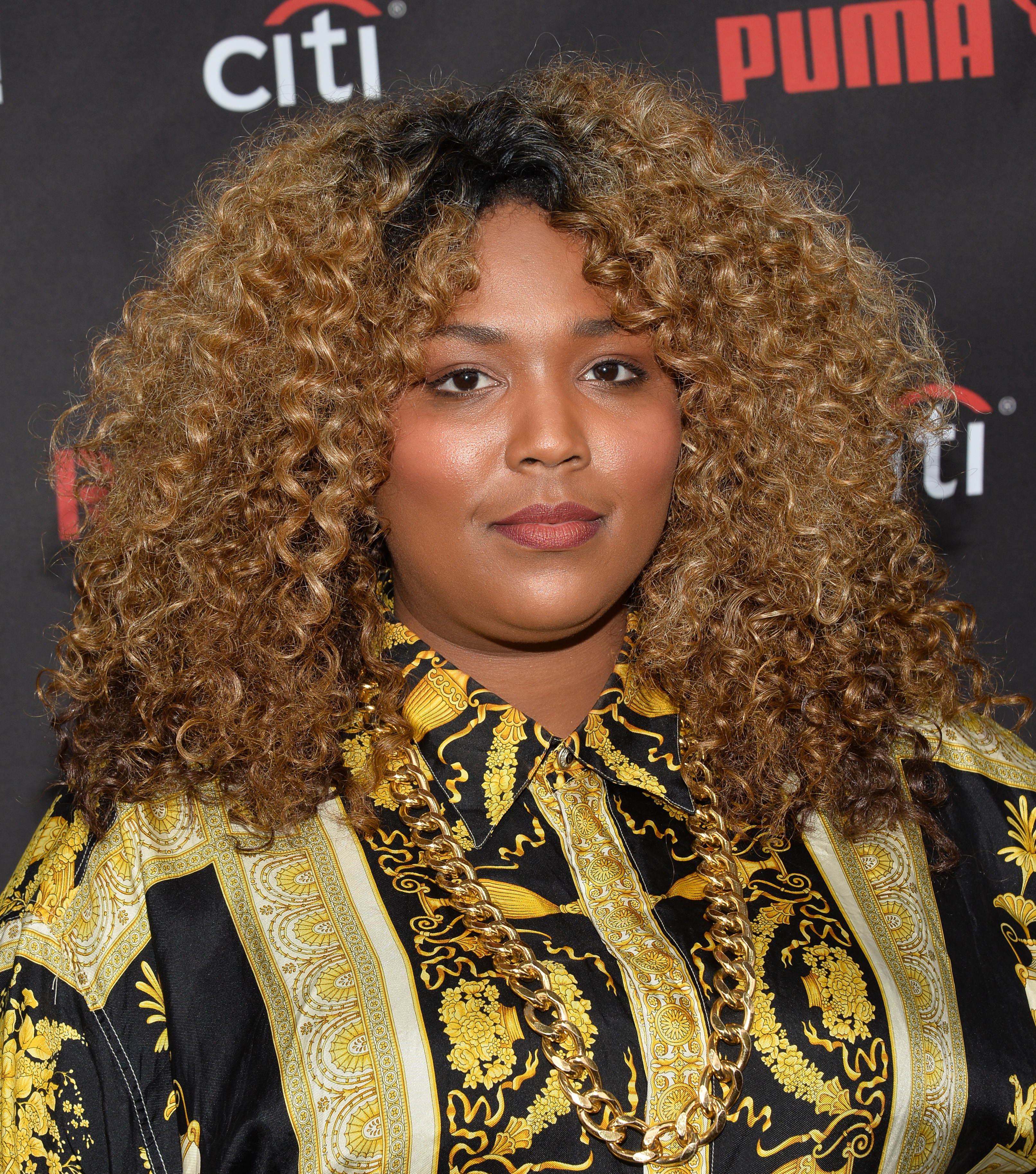 At the Roc Nation Grammy Brunch, Lizzo poses with quiet confidence, her expression composed as she steps into industry spaces still finding her footing. With bold prints and a statement chain, the look hints at the fearless style and presence already beginning to take shape.
