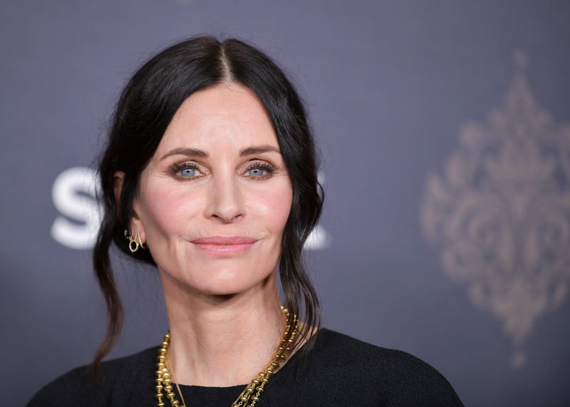 Courteney Cox showcases her post-pandemic style at the "Shining Vale" premiere on February 28, 2022, at TCL Chinese Theatre in Hollywood, sporting bright blush, a soft pale pink look, and gold jewelry accents.