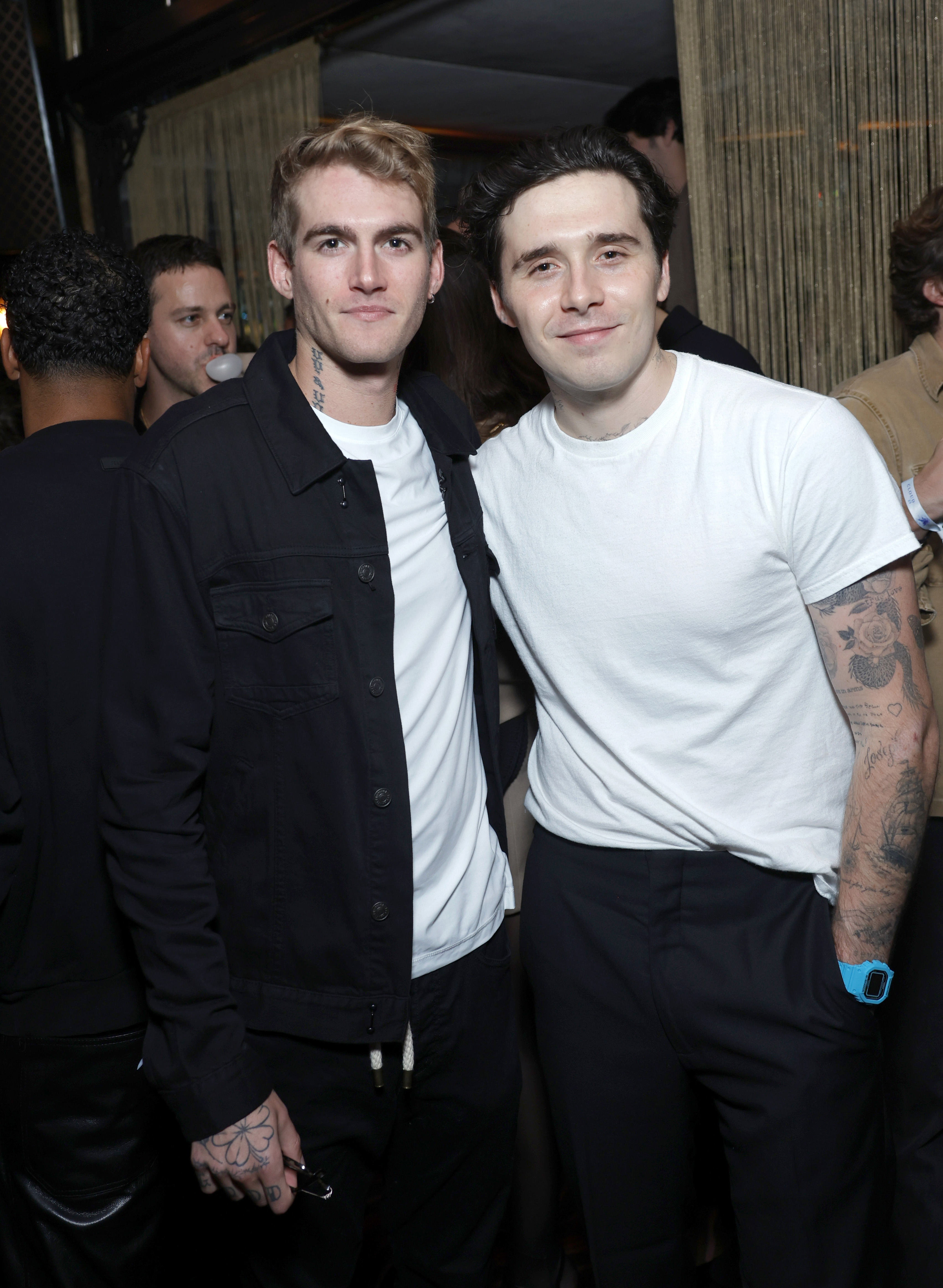 **GettyImages-2177914655 (1).jpg** Presley Gerber and Brooklyn Peltz Beckham posed together in stylish, coordinated casual attire featuring classic white tees and dark trousers while attending the Cloud23 launch party at Bar Marmont on October 10, 2024, in Los Angeles, California. | Source: Getty Images