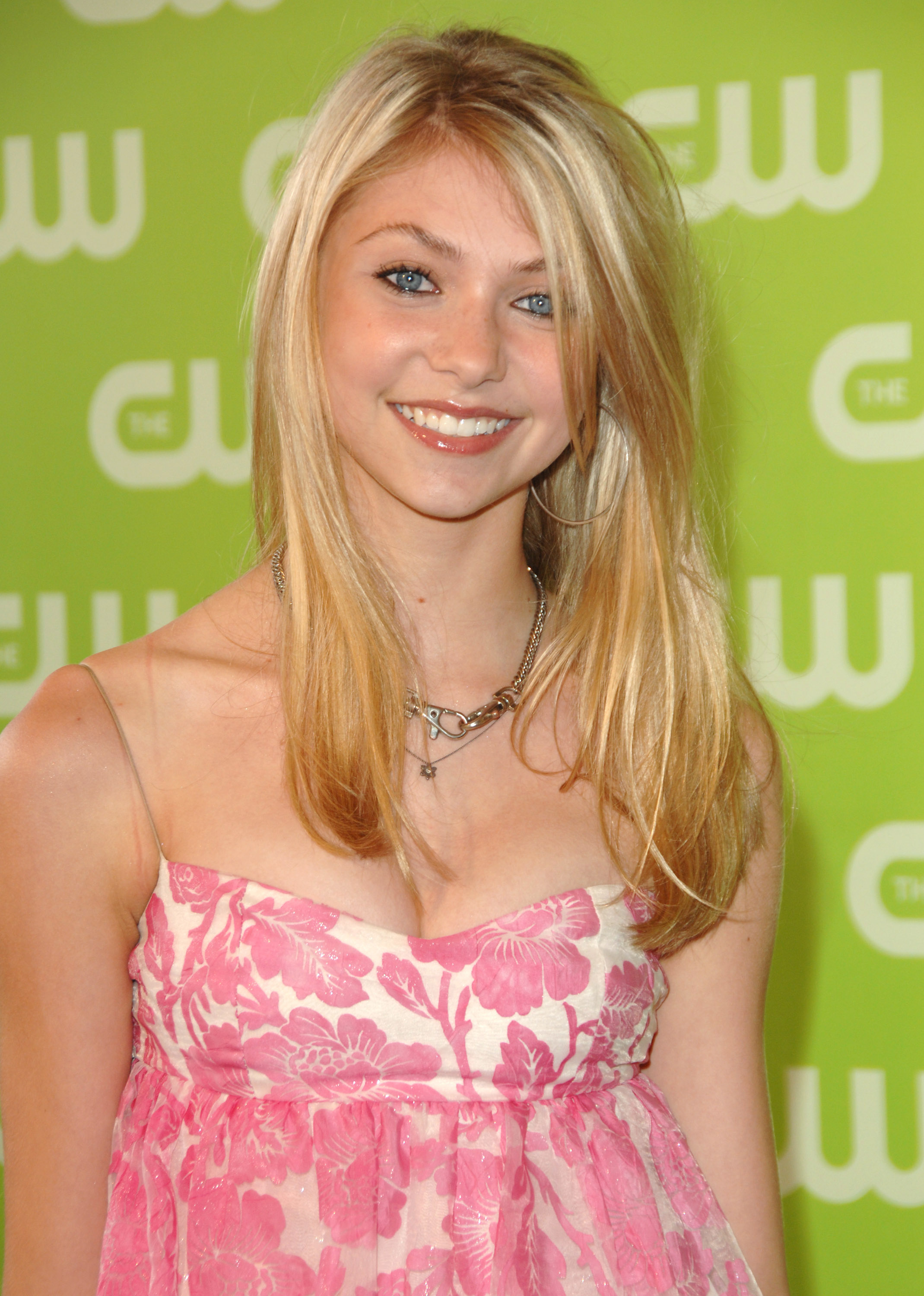 Taylor Momsen attends The CW Network Upfront at Madison Square Garden in New York City, glowing as a teenager in a pink-and-white dress with light makeup that highlights her natural beauty.