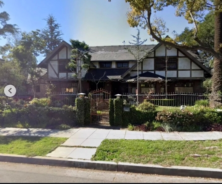 Another view from across the street provides a fuller look at the home's distinctive exterior, including its dark timber framing, pale walls, multiple gables, and deep front porch. Trees cast shade across parts of the property, while carefully shaped hedges flank the entrance and a metal fence separates the garden from the sidewalk decades after Marvin Jr.'s death. | Source: Instagram/stephanosmoothlewis