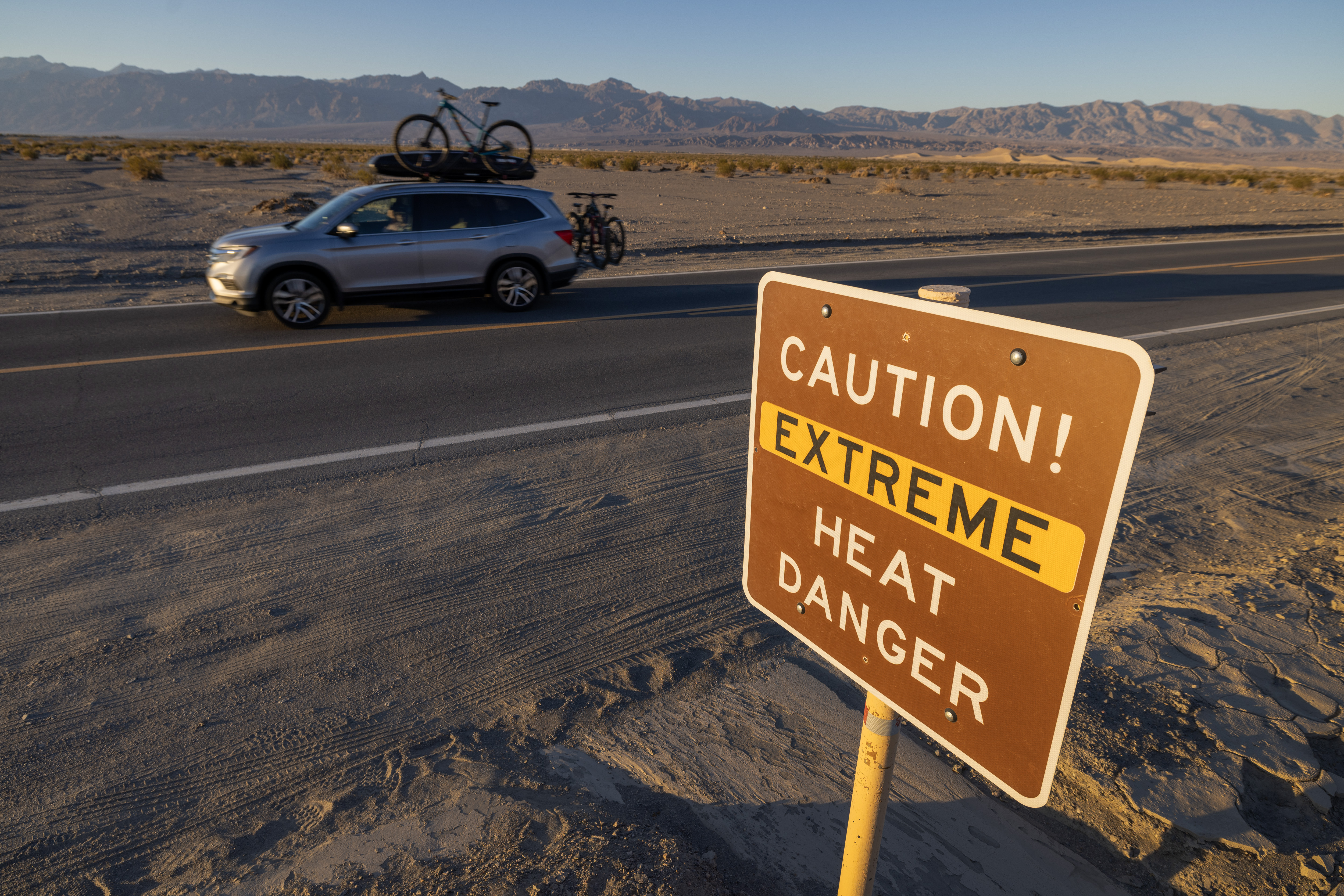 A vehicle drives past a warning sign for extreme heat danger in Death Valley National Park, California, on July 15, 2023 | Source: Getty Images