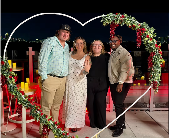 Pumpkin and Darrin pose with Alana Thompson and Dralin Carswell inside a heart-shaped arch decorated with greenery and red flowers. Pumpkin displays her new ring as the four celebrate the engagement beneath the city lights. | Source: TikTok/Mama P