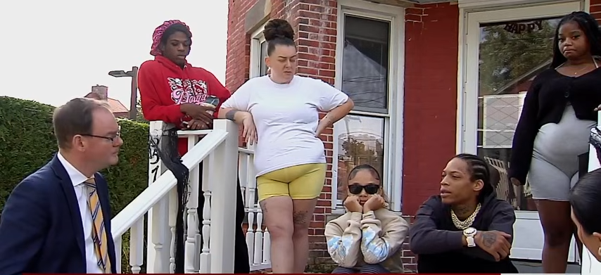 Josiah Alexander Ezekiel (seated, second from right) joins family members and others outside a home as the community struggles to come to terms with the horrific shooting that claimed nine lives. | Source: YouTube/@ErieNewsNow