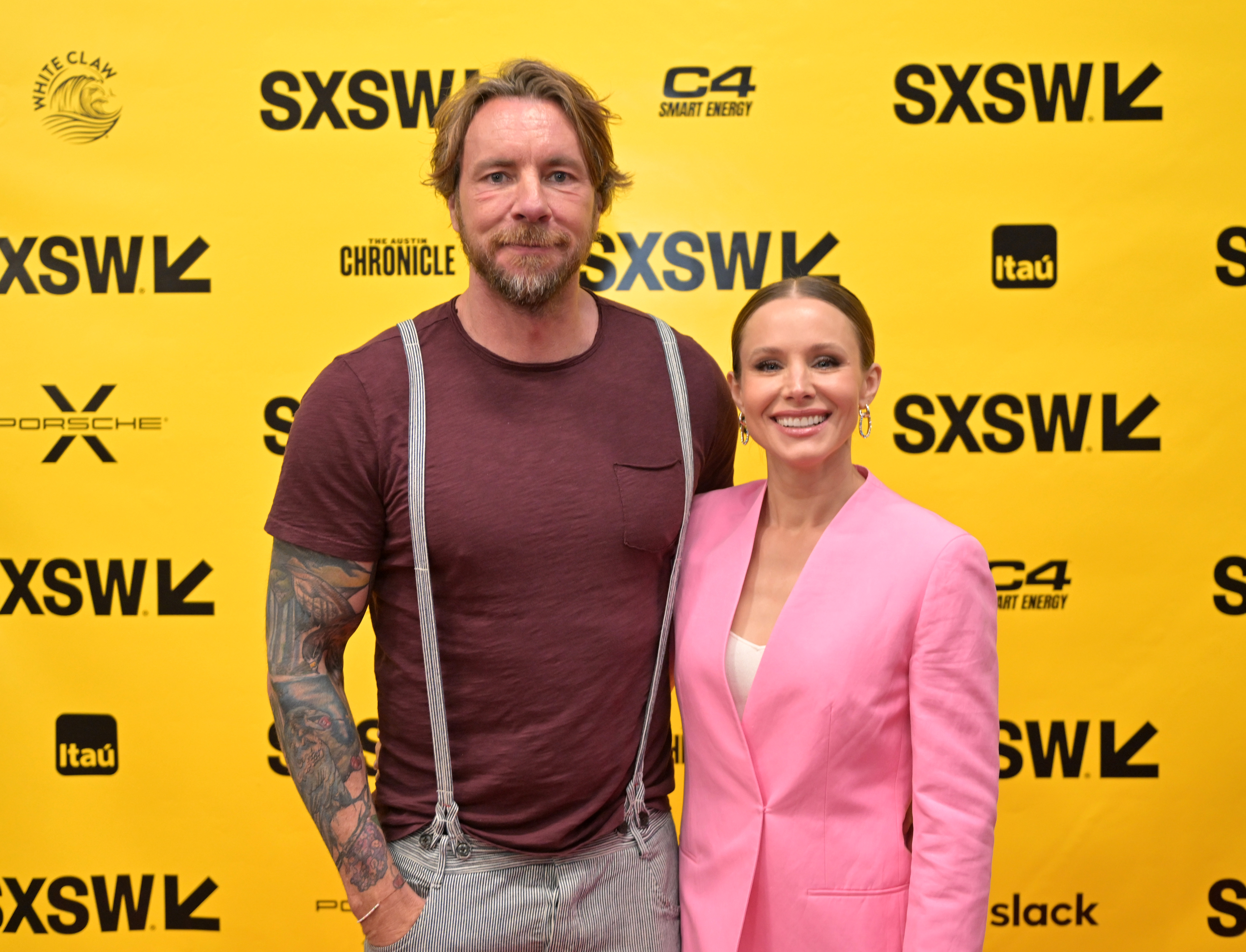 Dax Shepard and Kristen Bell attend SXSW, blending casual confidence with couple chemistry. His relaxed look and her bright pink suit create a fun, modern pairing on the festival's vibrant yellow carpet.
