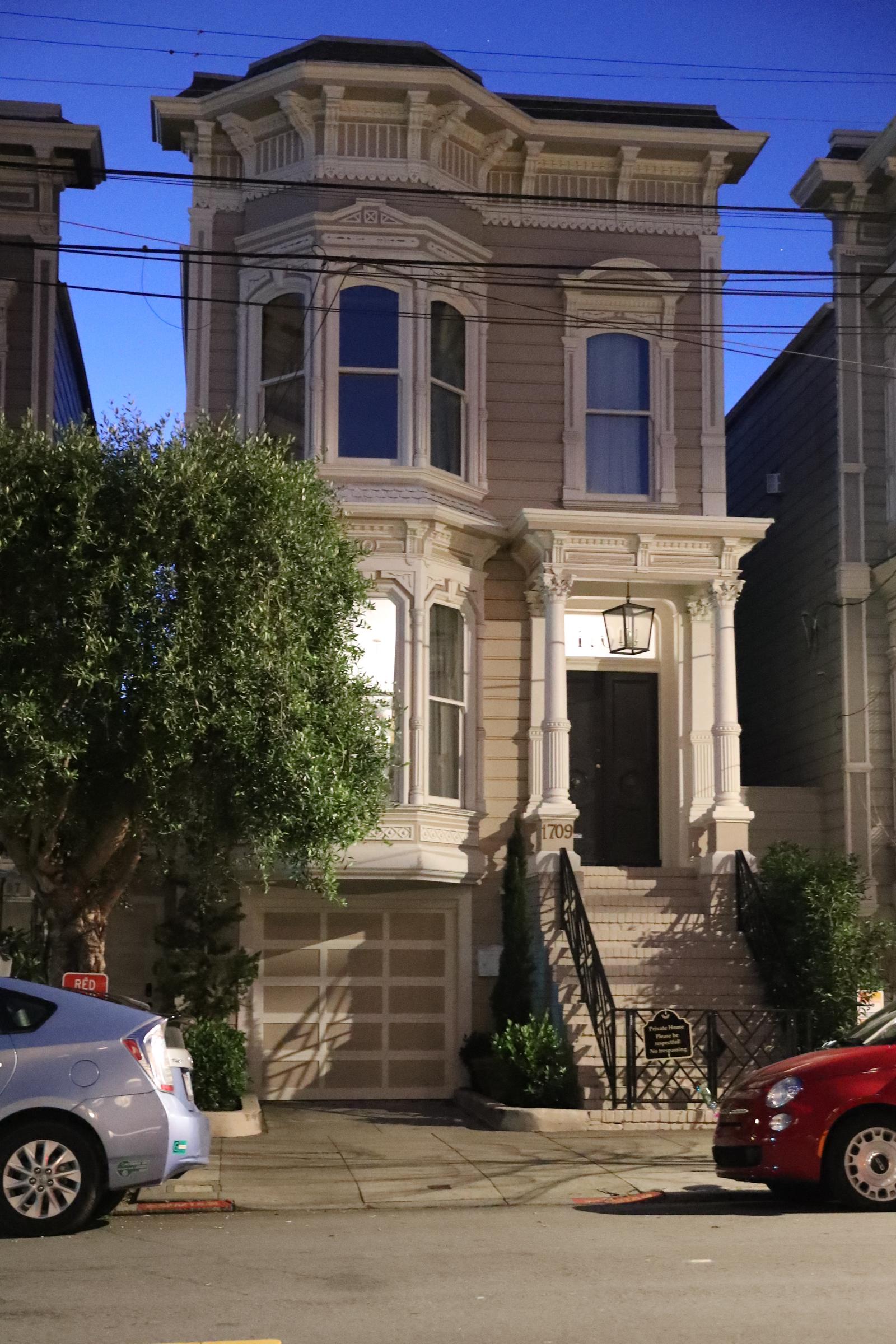 The iconic Victorian facade at 1709 Broderick Street in San Francisco stands illuminated at dusk on January 10, 2022. Instantly recognizable from the opening credits of "Full House," the landmark home served as the exterior backdrop for Danny Tanner's crowded, loving household. The quiet street scene carries deep emotional resonance for longtime fans, representing the heart of the television family built by Bob Saget, John Stamos, Lori Loughlin, Candace Cameron Bure, and Jodie Sweetin.