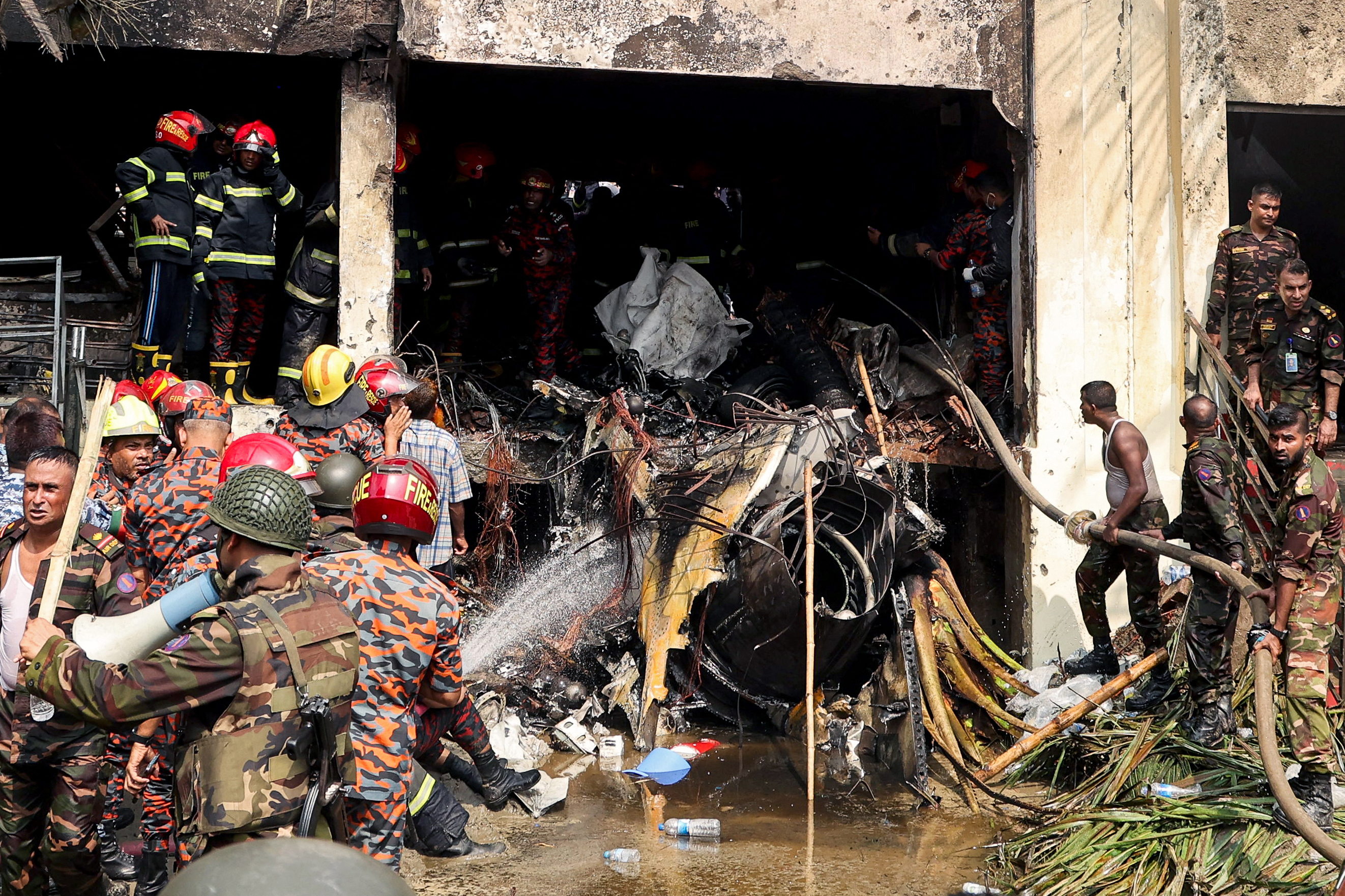 Bangladesh's fire service and security personnel conduct a search and rescue operation after an Air Force training jet crashed into Milestone School and College in Dhaka on July 21, 2025 | Source: Getty Images