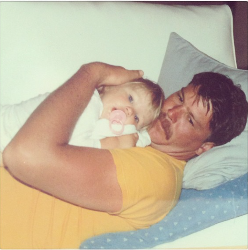 Candice Swanepoel shared a sweet childhood photo of herself cuddled up with her father, resting in his arms with a pacifier in her mouth. She captioned the heartwarming throwback, “Daddy's girl. | Source: Instagram/candiceswanepoel